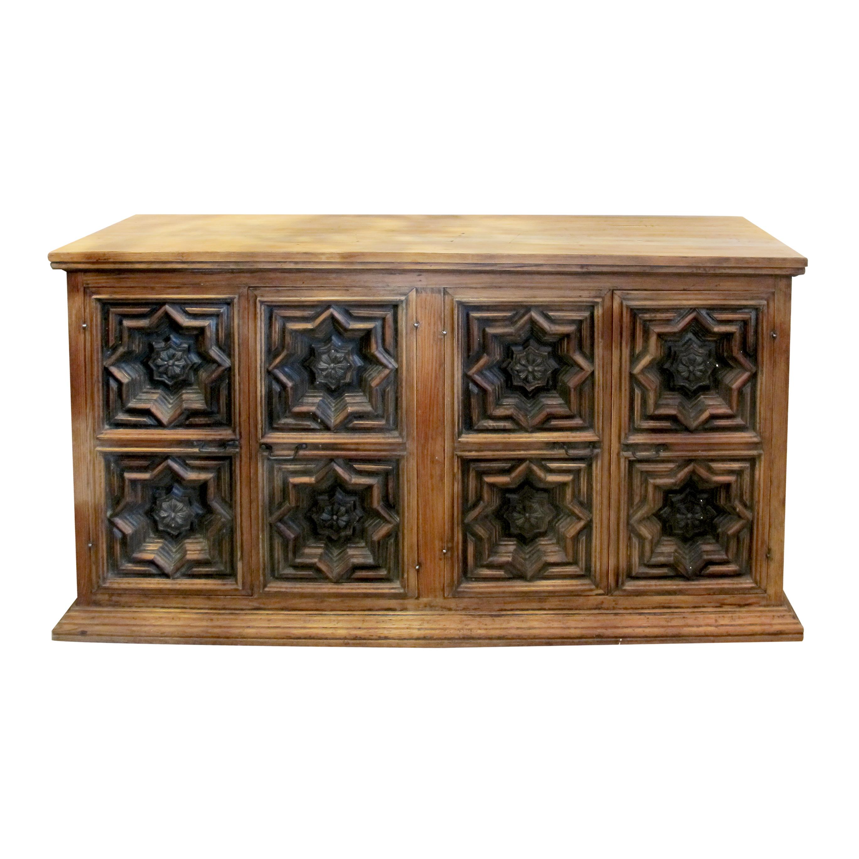 Questa credenza spagnola degli anni '60 presenta un design robusto e senza tempo. Il pezzo presenta due porte doppie, ciascuna con intricati intagli geometrici che aggiungono un'audace presenza architettonica. All'interno, un ripiano centrale ben