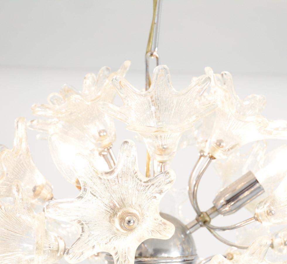 This chrome-plated Sputnik chandelier is finished with 30 transparent glass floral shades. It is a nice design of the 1960s.
The central chrome-plated sphere and the glass flower shades create a magnificent light.
We have 2 sputniks available,