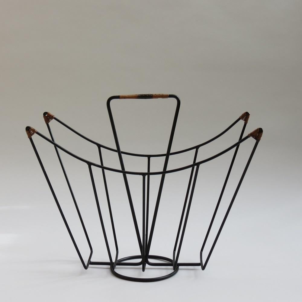 Very hard to find magazine rack designed by Desmond Sawyer and manufactured by Desmond Sawyer Designs Ltd, dates from the 1960s. 
Painted black steel rod and rattan decoration.  Very good quality, in good over all condition. 

Designed and made by