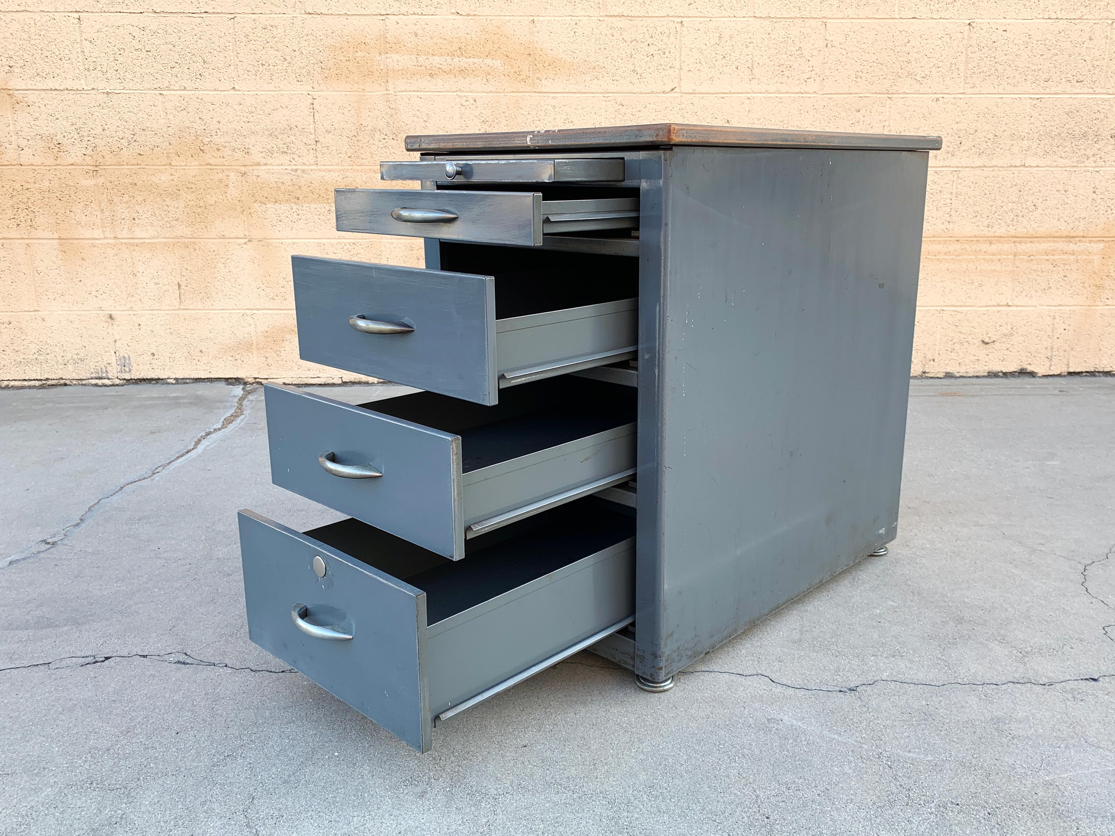 1960s tanker office cabinet by Tab Products Co., San Francisco. This heavy-duty, versatile piece features 4-drawers and a paper tray. The all steel body with thick Masonite and Formica top is in original condition, we did a light sand and clear