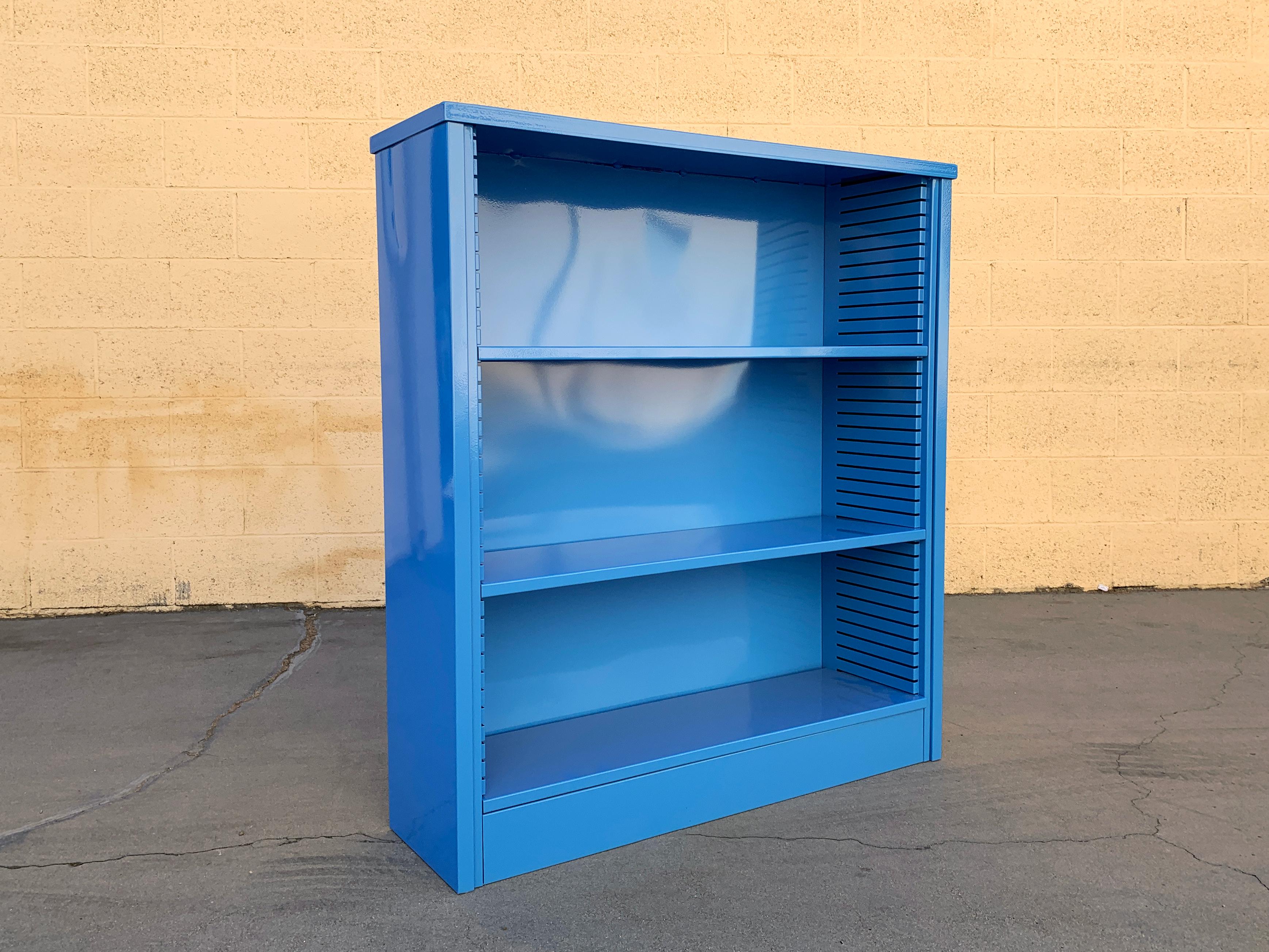 Neat 1960s tanker style steel bookcase freshly powder-coated in high gloss blue (BL05). This adjustable 3-shelf unit is an excellent storage option– its sleek and compact, yet holds many books. It's perfect for storage and display. Please not this