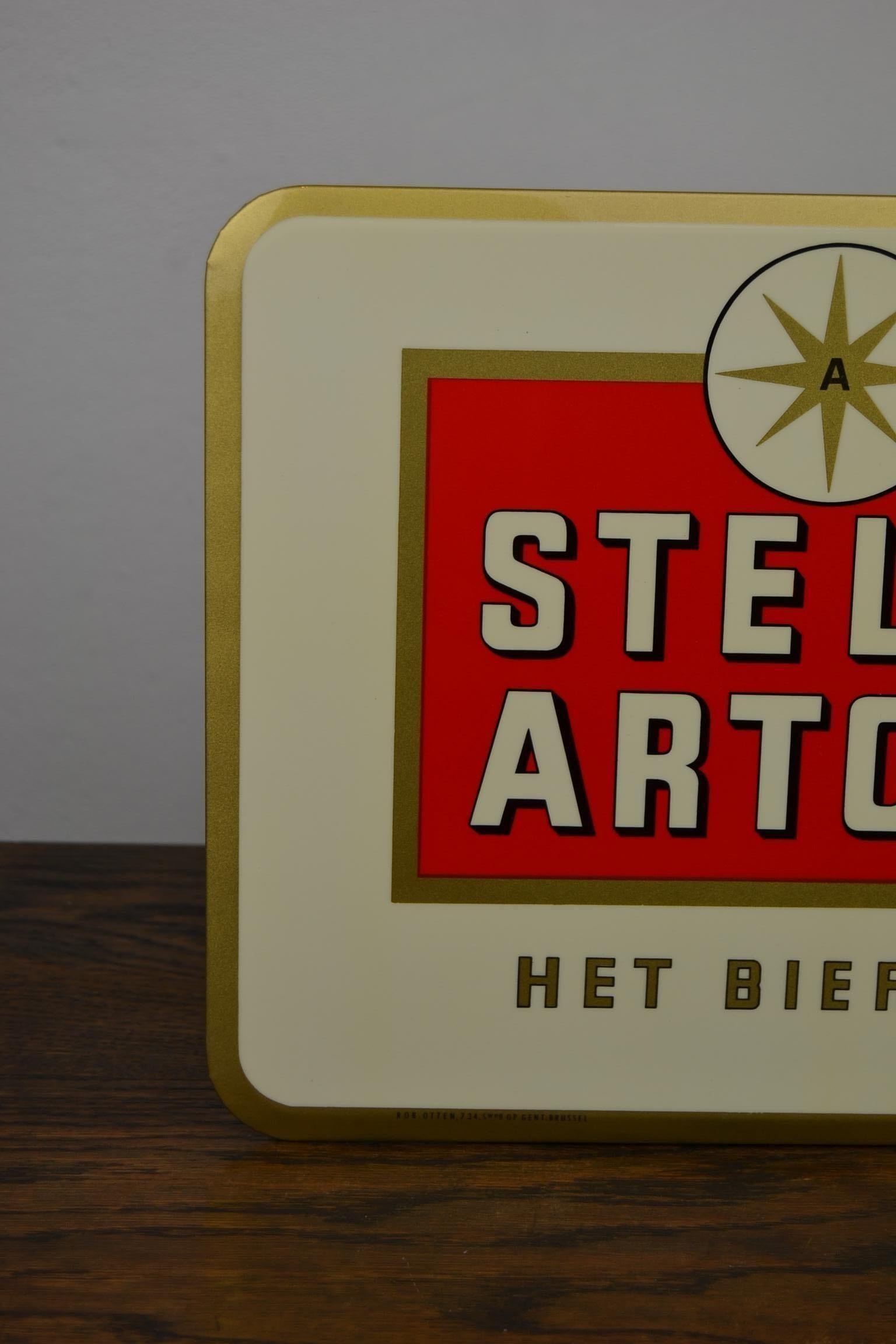 1960s Belgian Beer sign for the Beer Brand Stella Artois.
This Beer Sign is mounted on Cardboard. 
With tax stamp at the back.
It was made by the Company Rob Otten, which was located in Brussels.
Great design : a typical ribbed glass of Stella