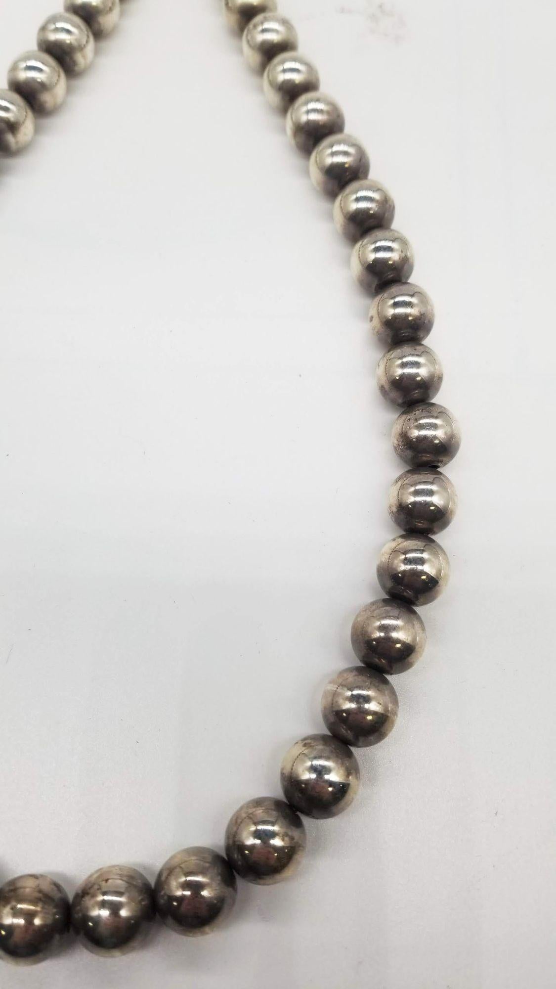 This 1960s silver beaded necklace is a vintage treasure, exuding retro charm and timeless elegance. Each delicate silver bead is meticulously crafted, reflecting the era's sleek and sophisticated style. This piece effortlessly adds a touch of