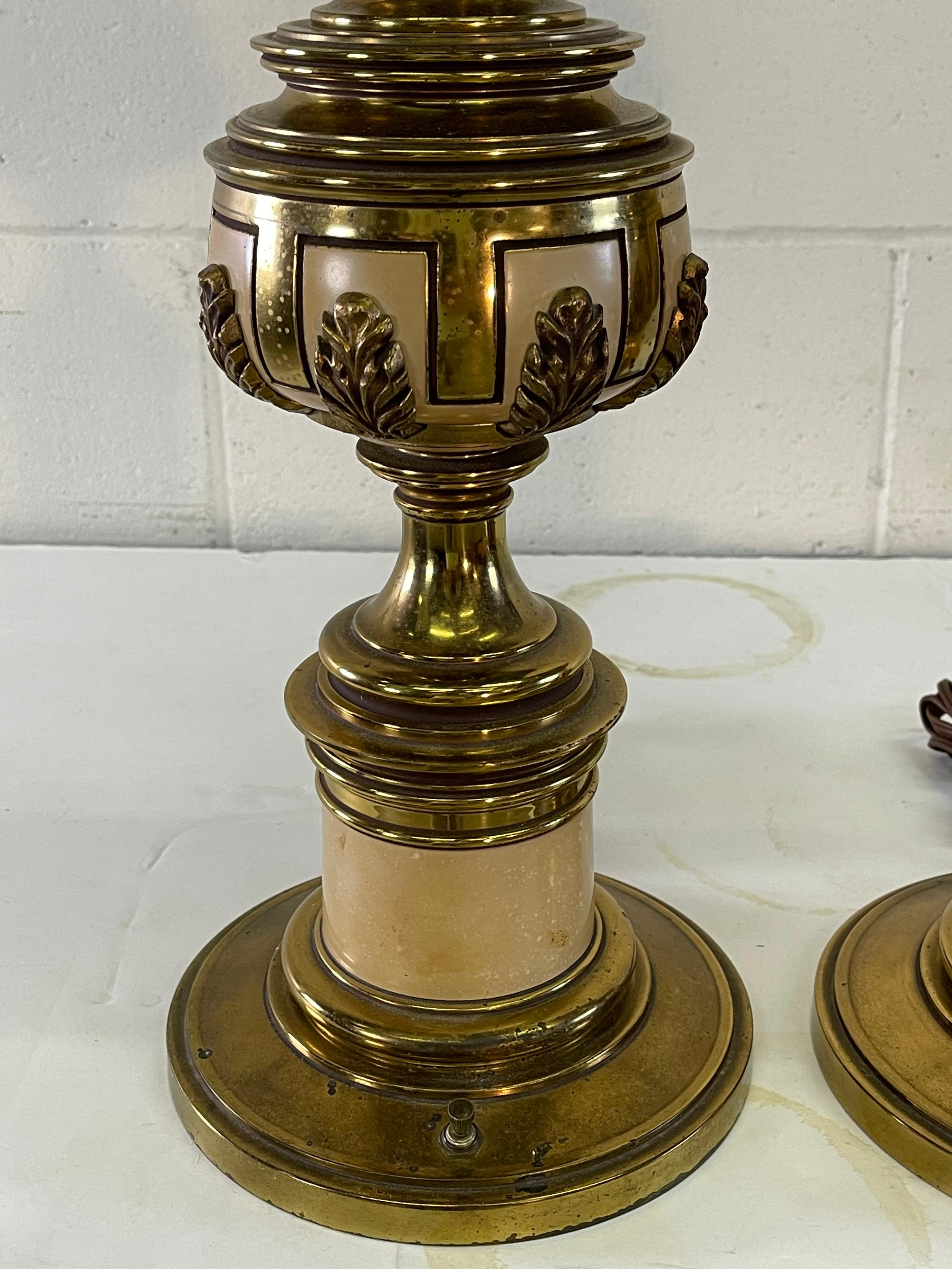 Vintage Stiffel pair of brass table lamps with a leaf accent. The pair are wired for the US and in working condition. Uses standard three-way bulb. Socket, 27.75”H. Harp, 4.5” diameter x 11” height. Light tarnish from age. Marked.