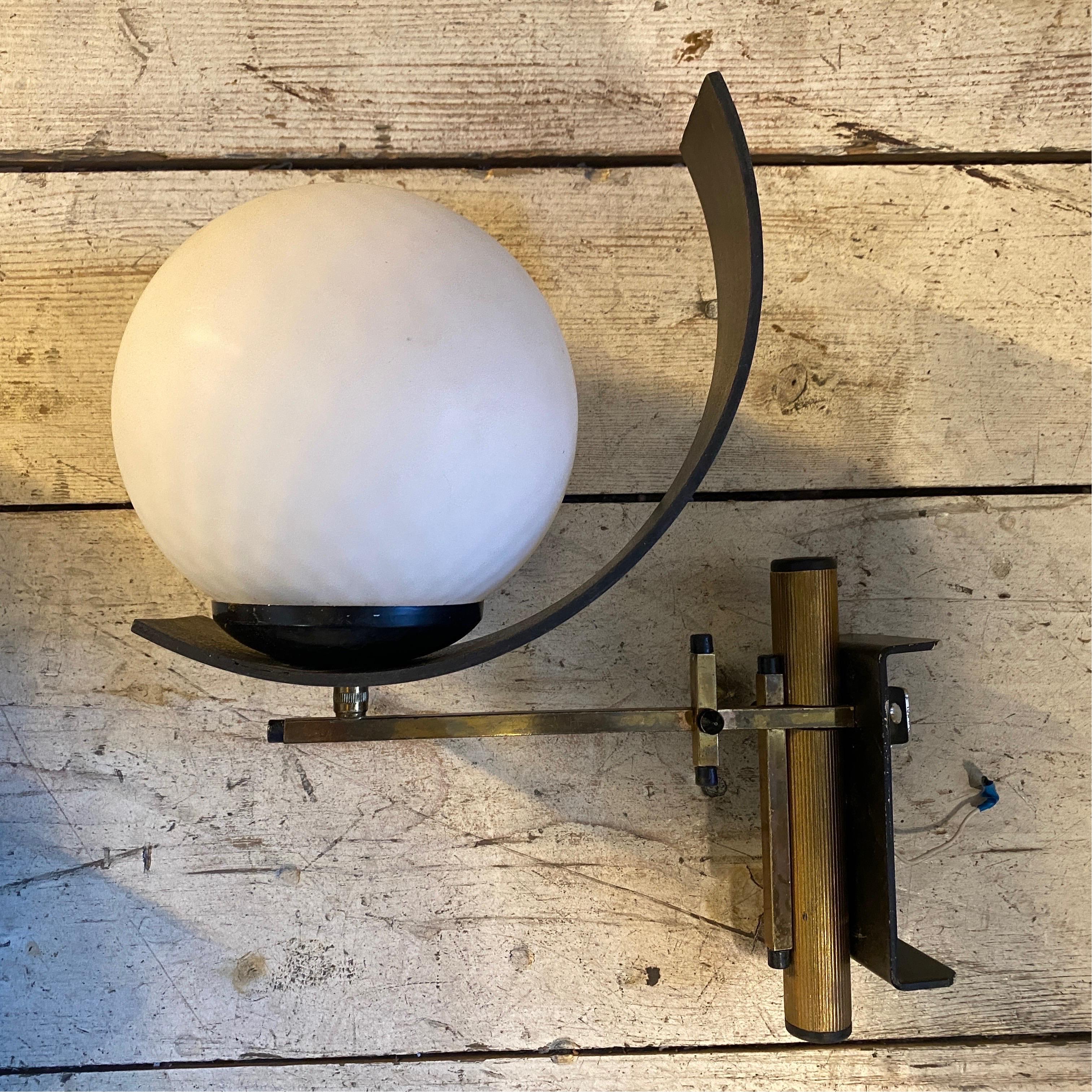 Three rare wall sconces made in Italy in the Sixties, brass and metal are in original patina, the white opaline round glass diffusors gives them a vibrant vintage look, they are sold one by one. The Set of Three Wall Sconces is a remarkable
