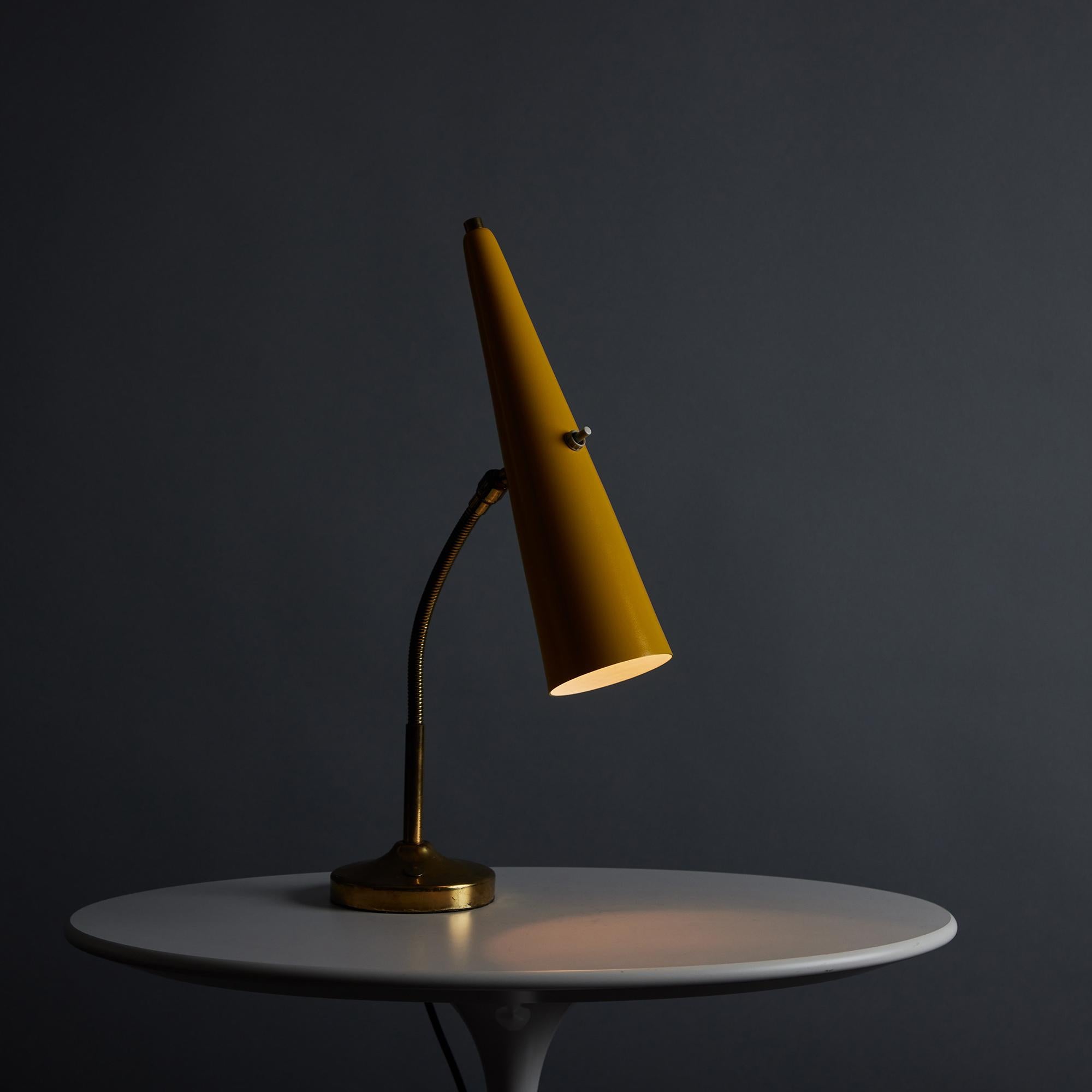1960s Stilux Conical Yellow Metal and Brass Table Lamp. This quintessentially midcentury Italian table lamp is executed in a long conical yellow painted metal shade mounted on a patinated brass goose-neck arm with circular base in very good vintage