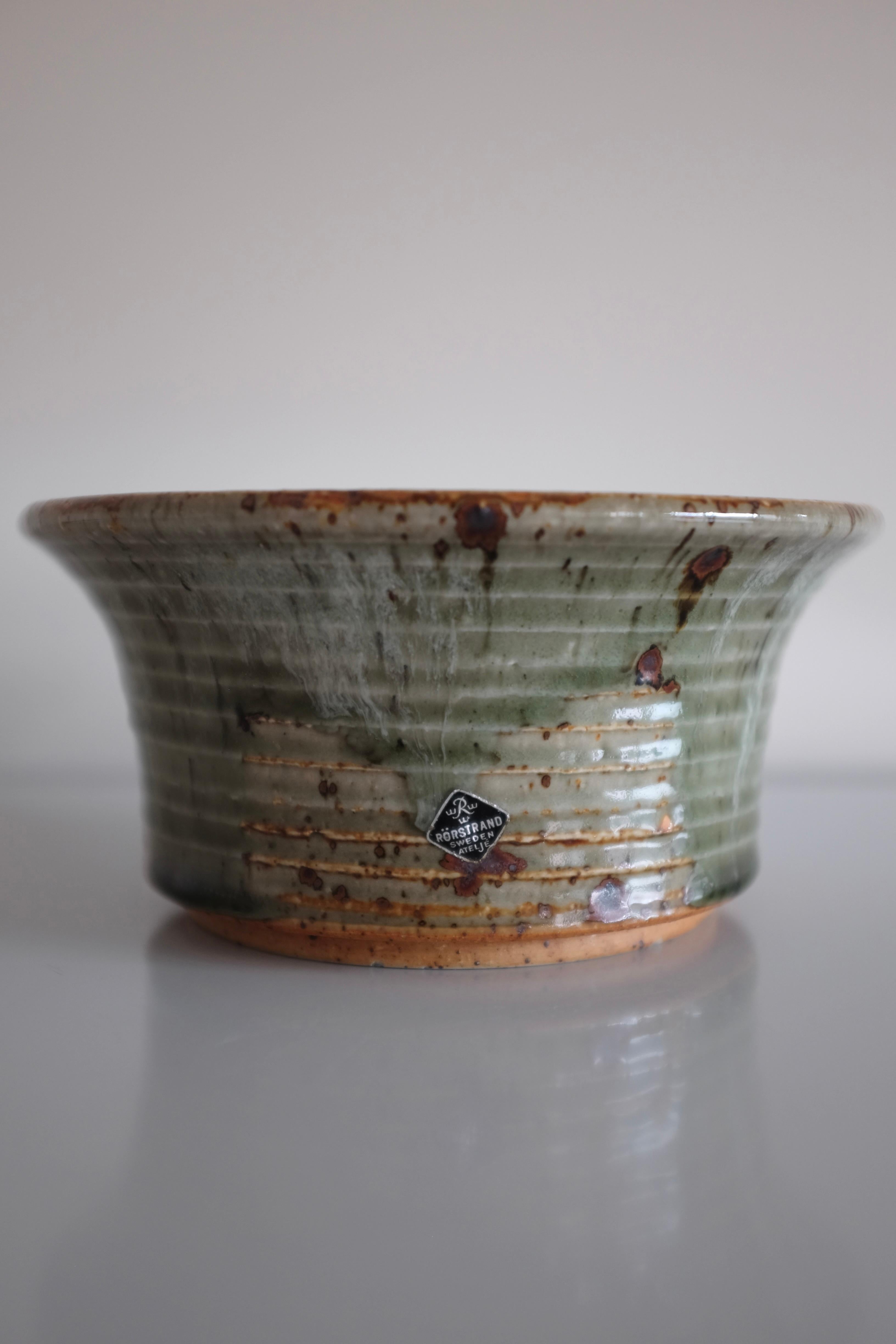 Rara ciotola in grès lavorata a mano negli anni '60 dall'artista svedese Marianne Westman. All'interno è presente una forma a spirale in una splendida vetrata verde. Realizzato presso l'Ateljé di Rörstrand in Svezia, dove Mariane Westman ha prodotto