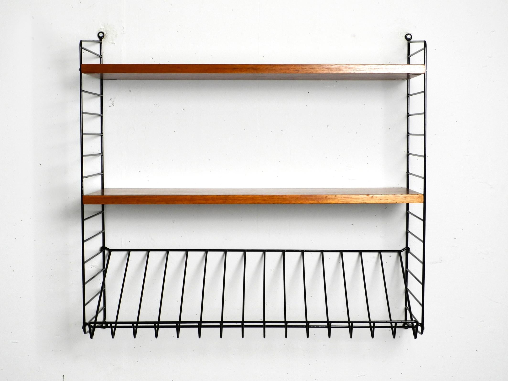 Original 1960s Nisse Strinning String teak wall shelf. Made in Denmark.
Two deep ladders with two 30 cm deep boards and one magazine rack.
All wooden parts are covered with teak veneer.
Very clean with few normal signs of wear.
All ladders are
