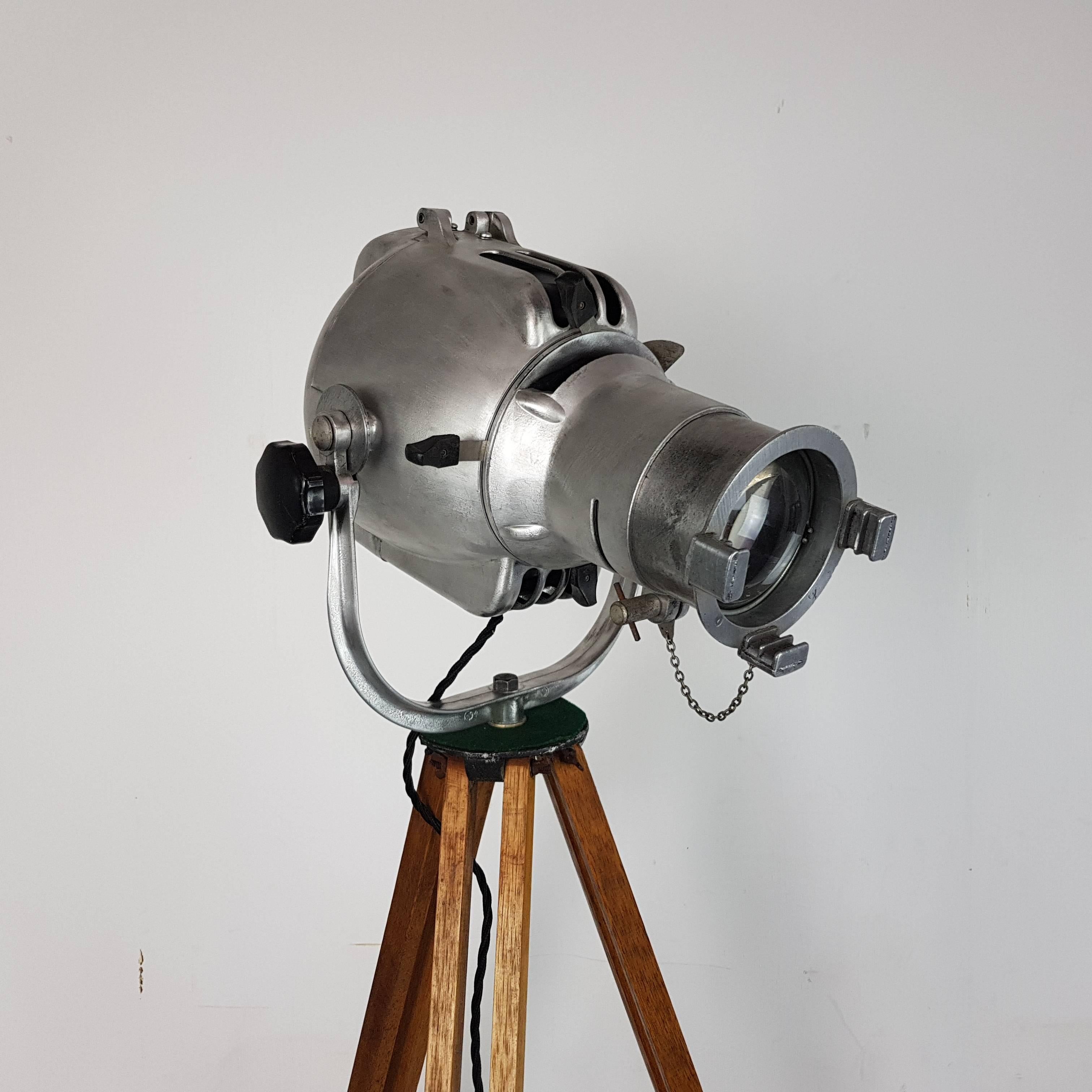 1960s Strand 23 theatre light, stripped and polished to a raw metal finish, mounted on a vintage wooden tripod.

The lamp is in full working order, has been newly rewired and has an on/off switch.

The bulbholder has been replaced with a new one