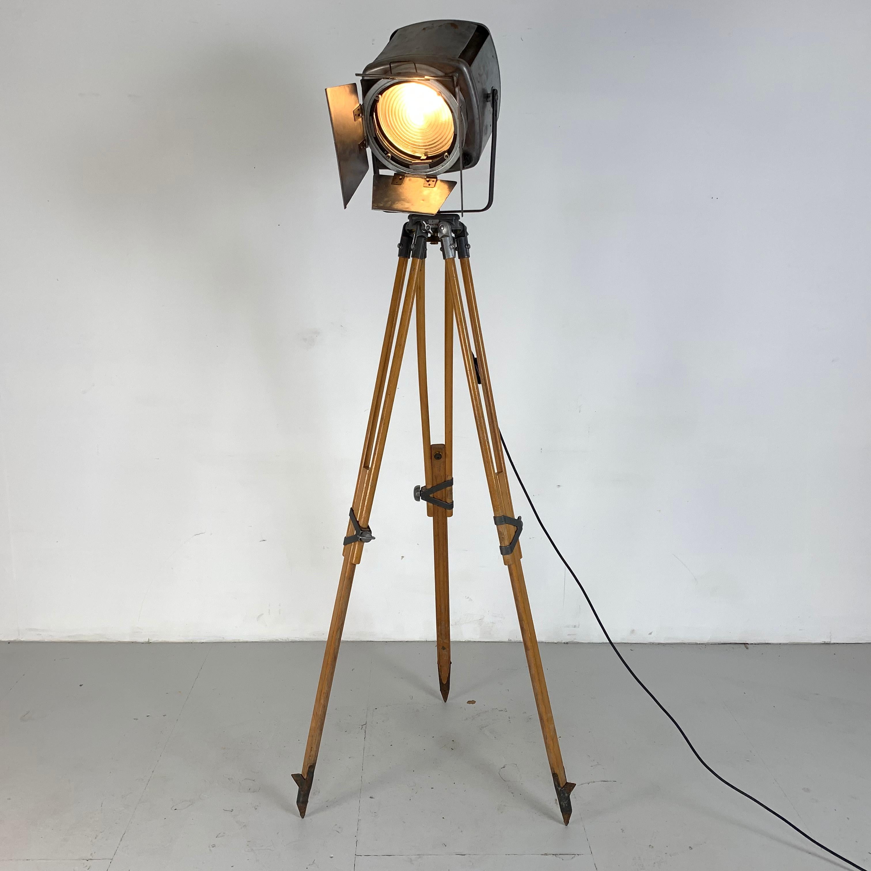 1960s strand 743 theatre light, stripped and polished to a raw metal finish, mounted on a vintage wooden tripod and still has its barn doors.

The lamp is in full working order, has been newly rewired and has an on/off switch.

The bulb holder