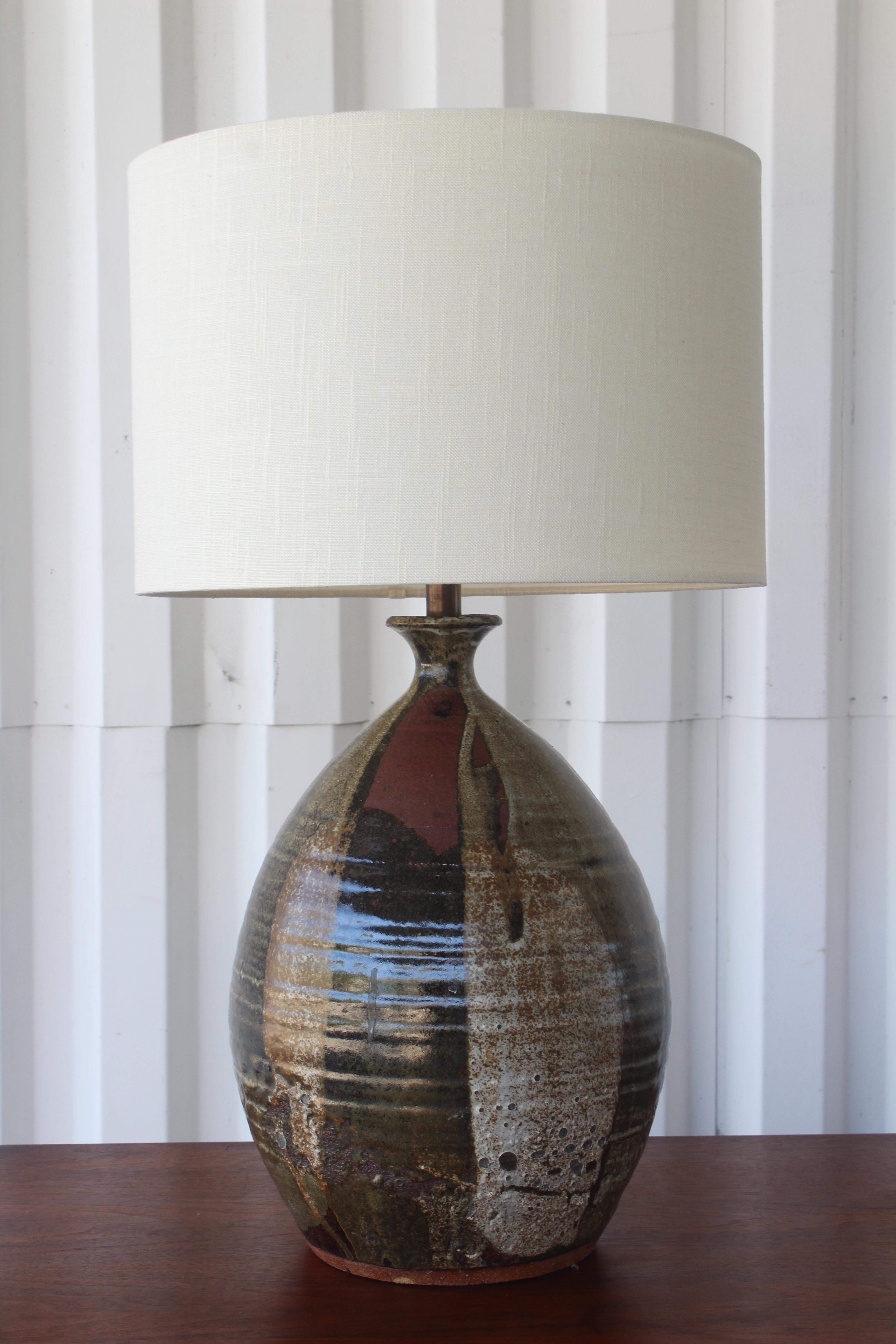 Vintage 1960s stoneware studio ceramic table lamp with drip glaze. Newly rewired with custom made shade in Belgian linen.
Measures: 26 inches high with shade, 16 inch high base. Lamp base is about 12 inches in diameter. Lamp shade is 15 x 15 x 10.