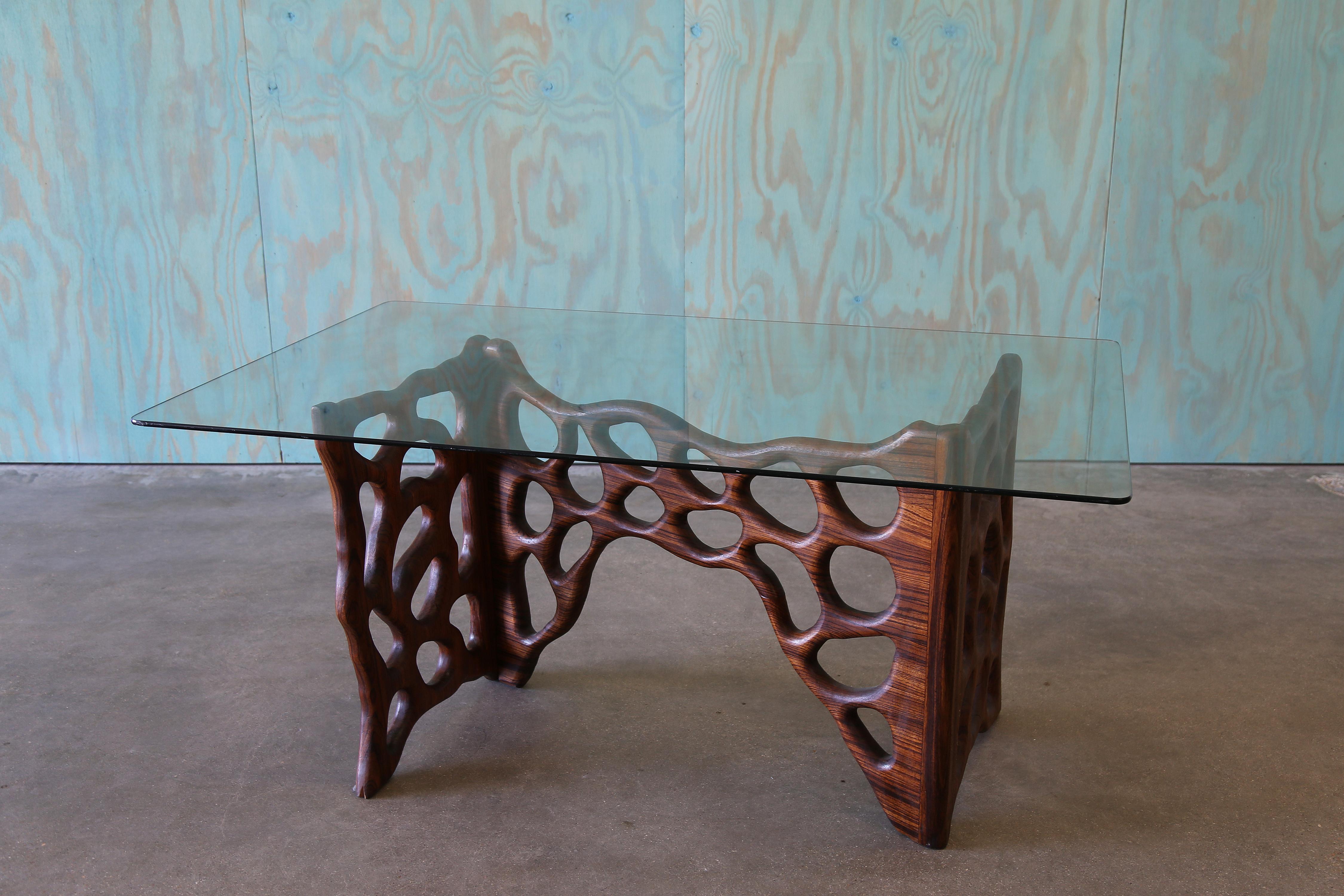 Une base de table vintage d'après le travailleur du bois Gino Russo. Le bois exotique a un grain très expressif, accentué par des trous biomorphiques taillés et façonnés à la main. Le design confère une certaine légèreté à la base, par ailleurs