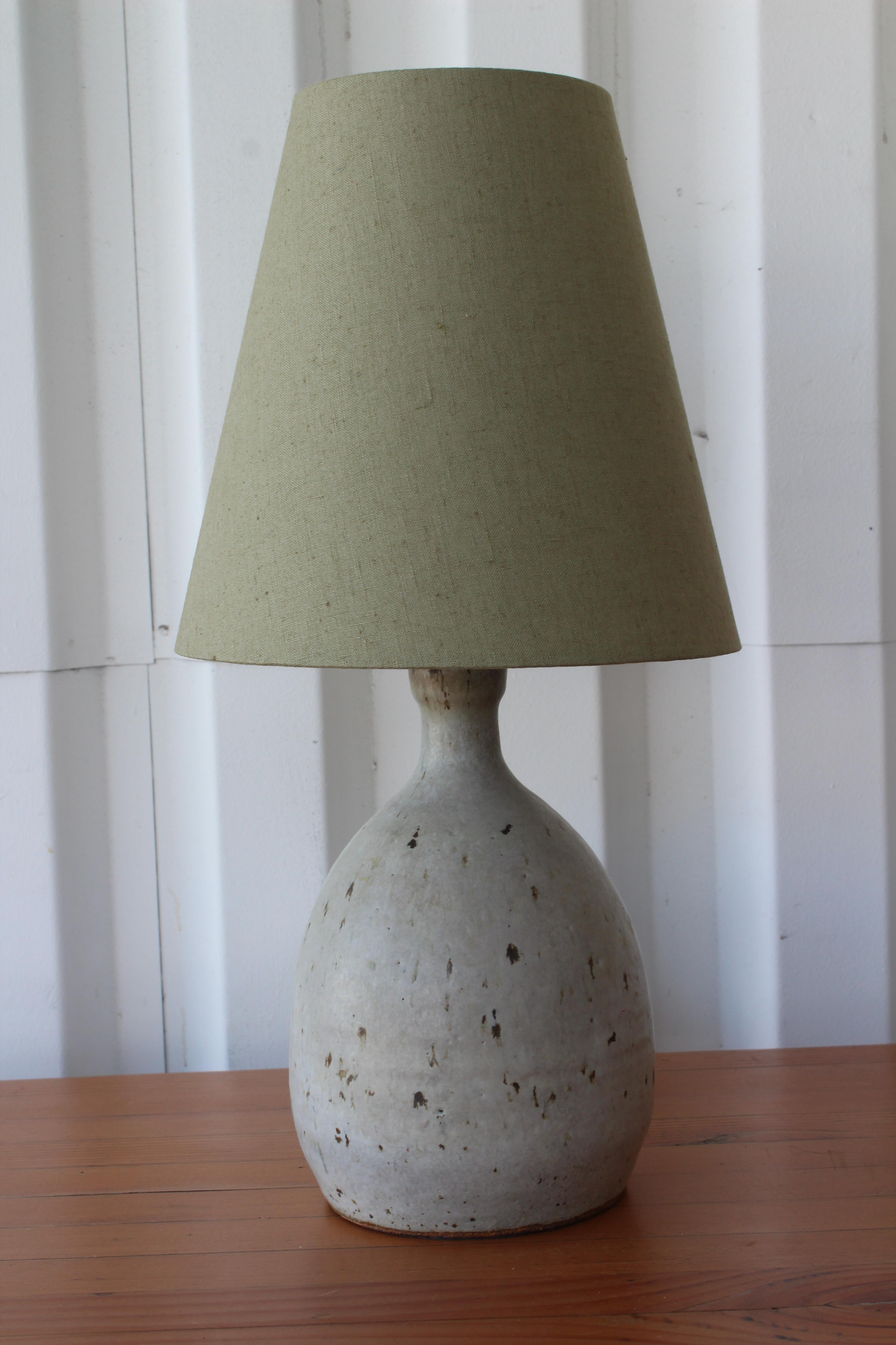 Petite 1960s studio pottery lamp. Newly rewired and fitted with a custom made lamp shade in olive green linen. 18