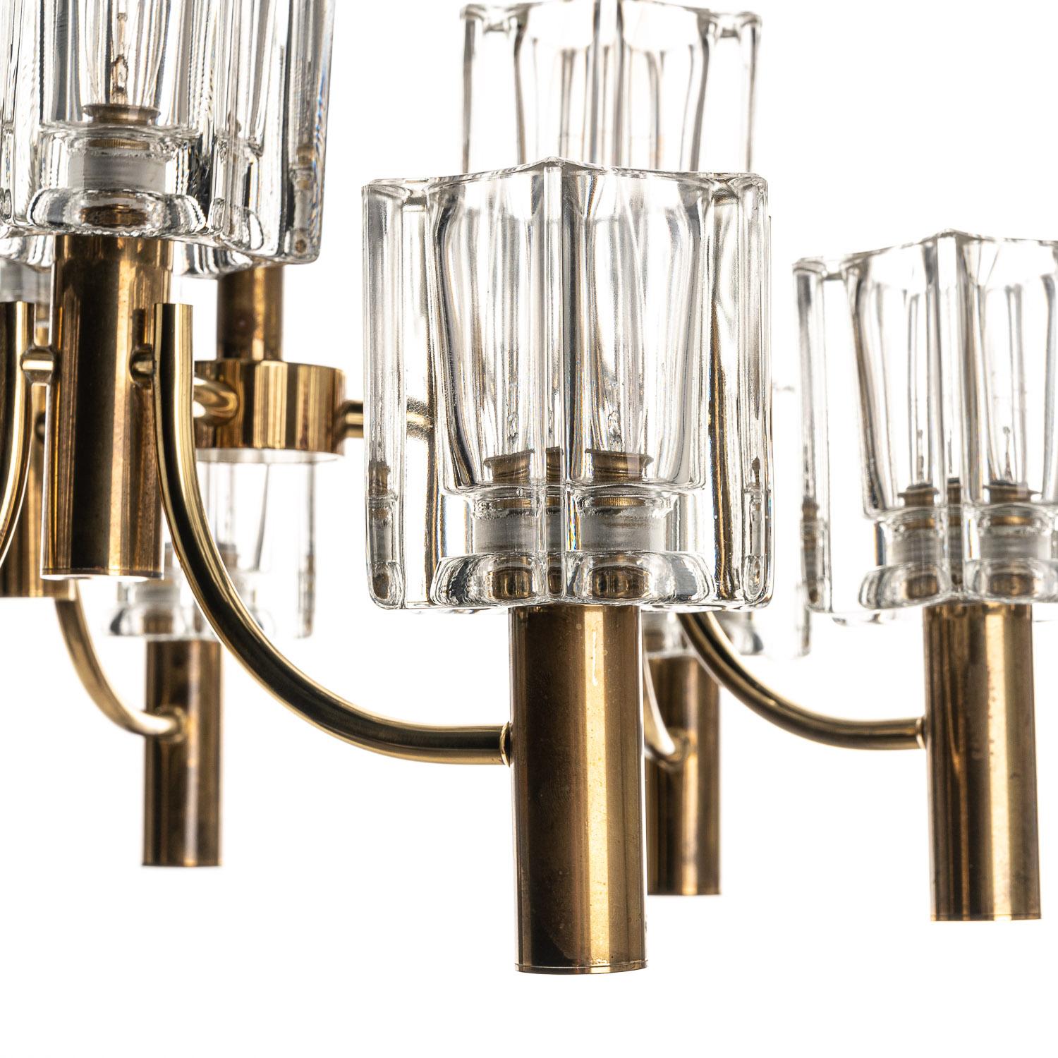 Stylish chandelier consists of 3 arms with each 3 beautiful pressed glass cups. The combination of the brass & glass, make it an eye catcher! 
Weight of this feature = 20 kilo.