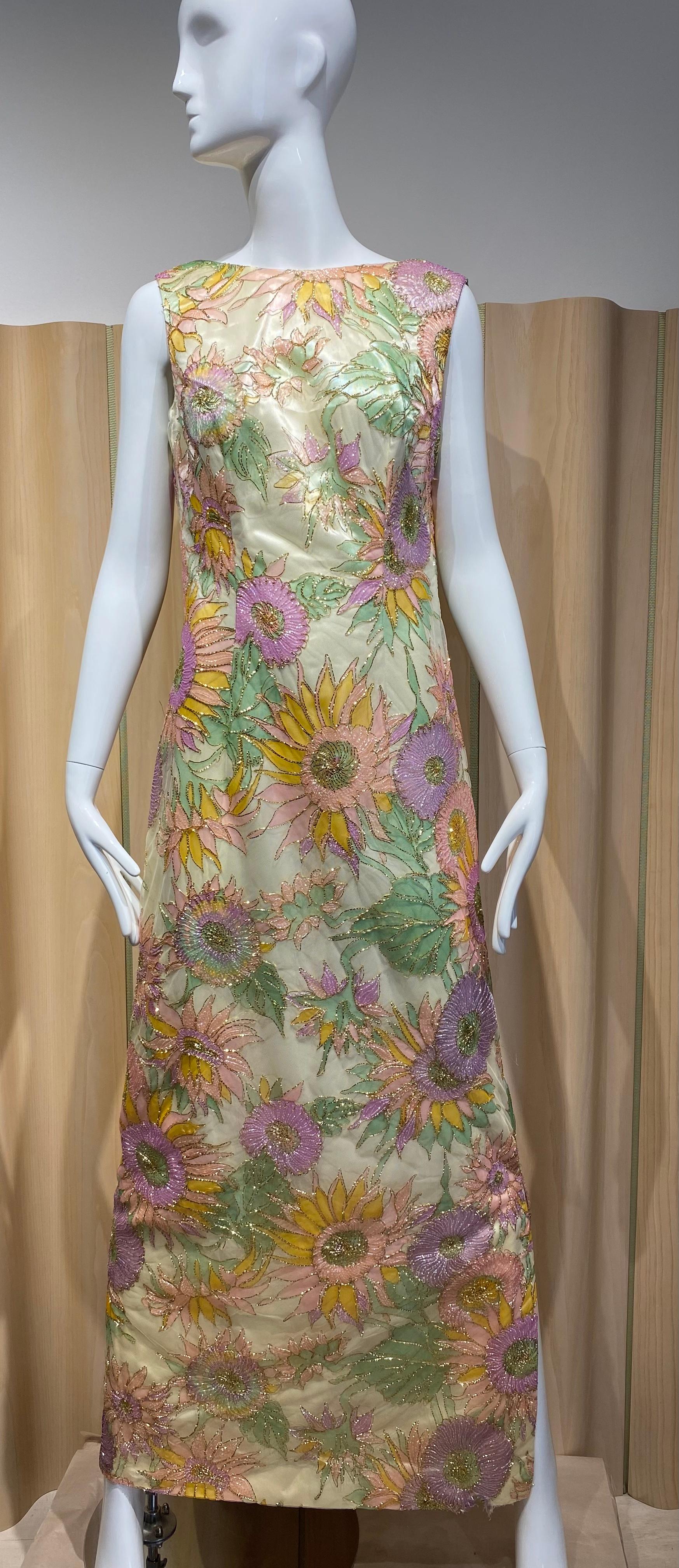 1960s custom made sleeveless shift cocktail dress in multi color sunflowers embroidered in gold metallic floral netting overlay.  Perfect for mother of the bride or wedding . 
Color : Yellow, Pink, light green and purple
Fit size Medium
Bust : 38” /