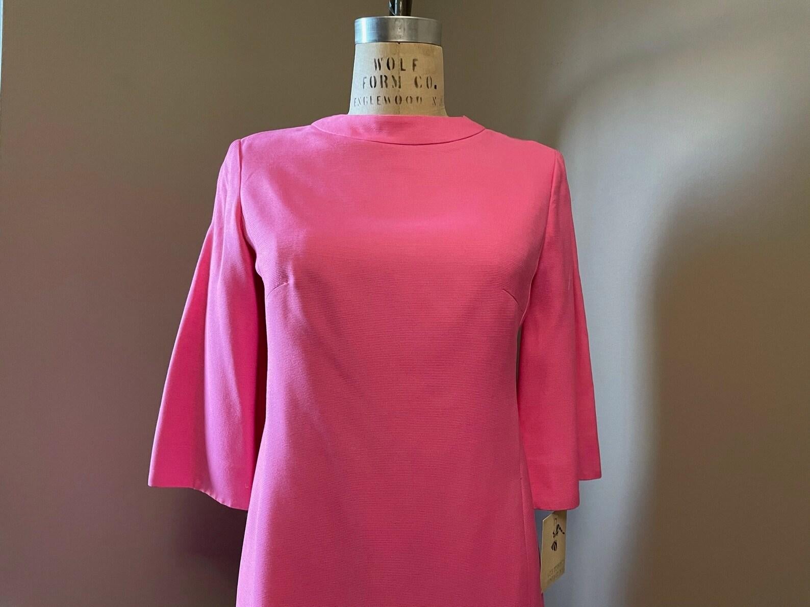 ○ ¡Vestido rosa de Suzy Perette de los años 60!
○ silueta de turno
○ cuello redondo
○ Mangas de campana 3/4
El vestido llega hasta la rodilla
○ totalmente forrado de tafetán de seda rosa
○ Cierre trasero con cremallera metálica

Alrededor de