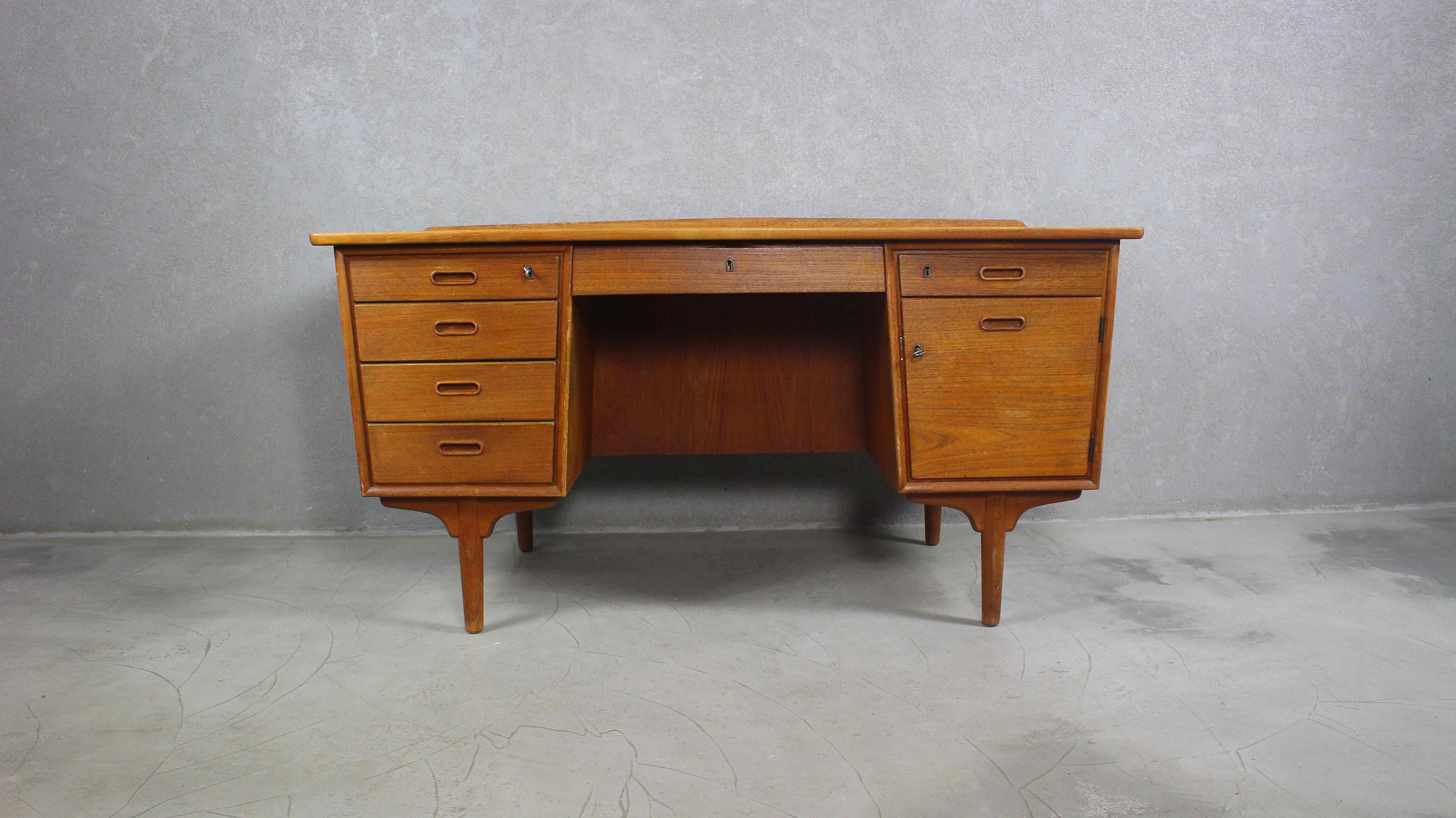 This teak writing desk was designed by Svend Aage Madsen (attributed), Denmark 1960s.
It features four drawers on the left side and one drawer and a cabinet on the right side.
On the backside is a large cabinet with a shelf which makes it also