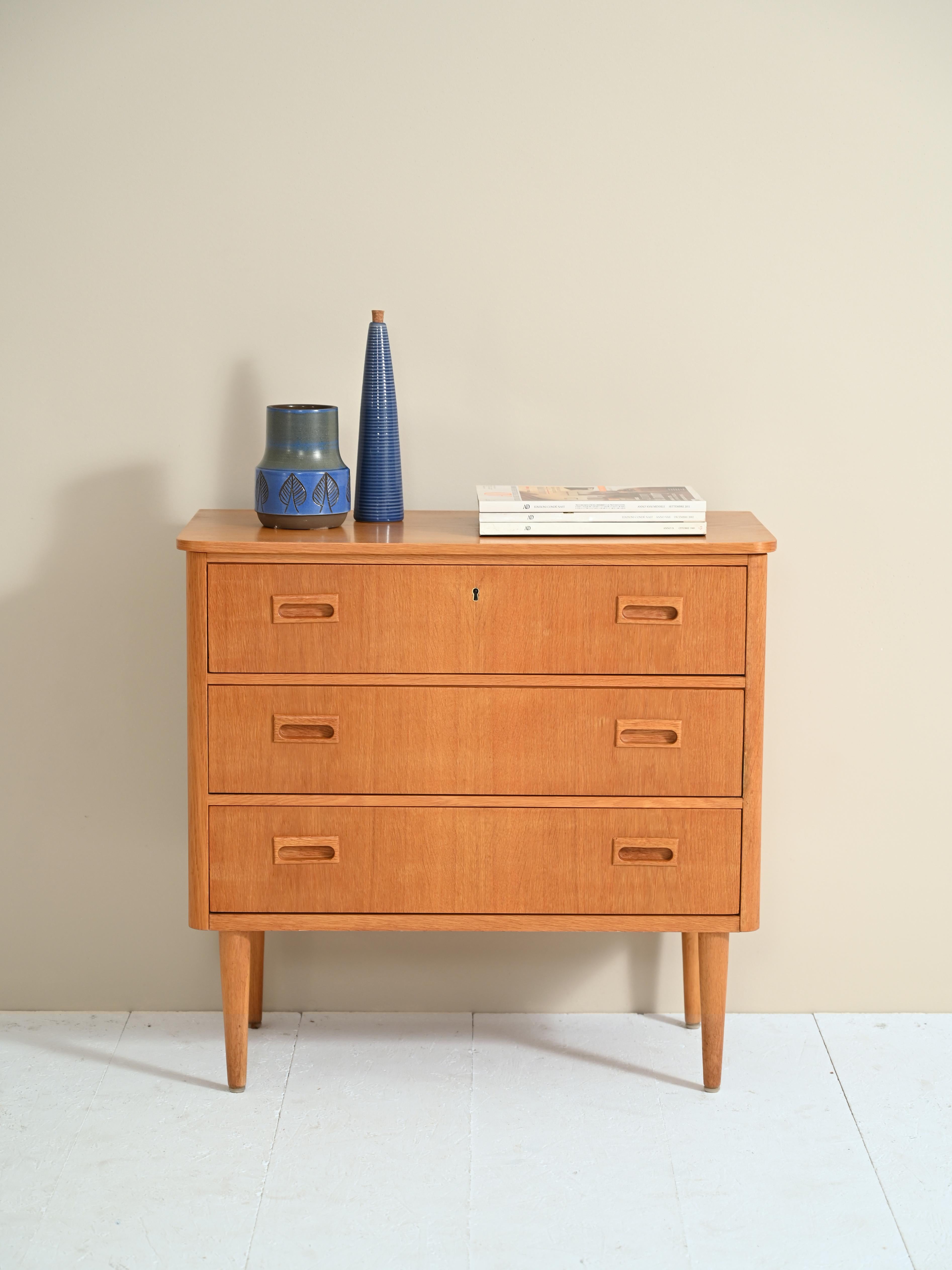 An original vintage chest of drawers from the 1960s, the Swedish provenance is evident in the quality and design of the clean, elegant shapes. 

There are three drawers with a finely carved wooden double handle and three locks that allow the drawers
