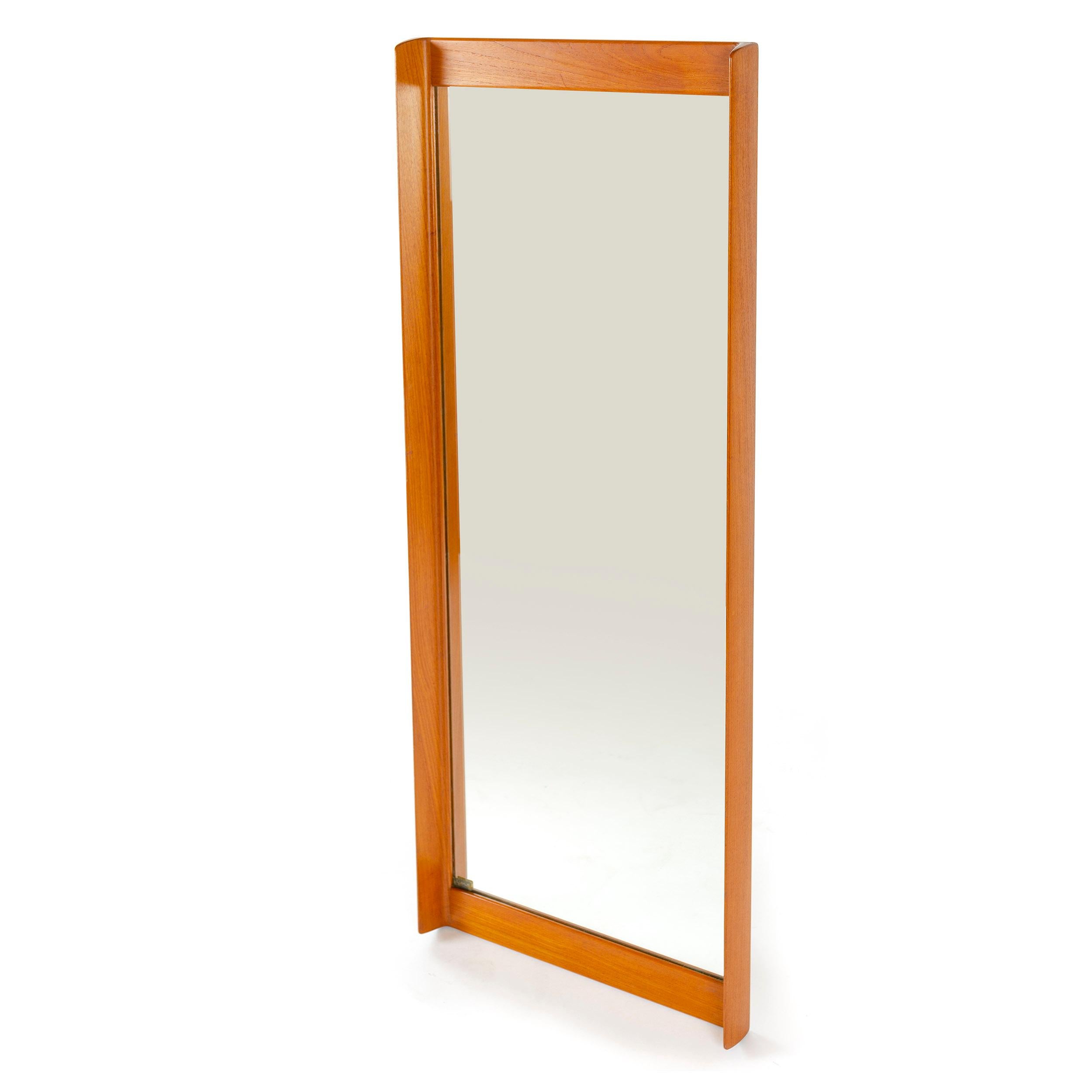 An elegant wall mirror manufactured in Sweden with a handcrafted teak-frame with bowed sides and original glass.
