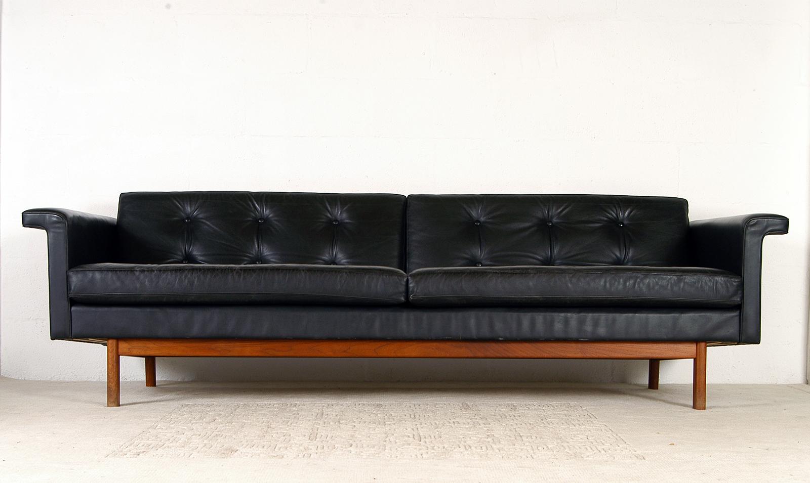 Designed by Karl-Erik Ekselius and produced by J.O Carlsson of Vetlanda, this sumptuous black leather sofa is quite clearly a Modernist designers interpretation of a Classic English ‘Chesterfield’ sofa with its deep button tufted upholstery, rolled