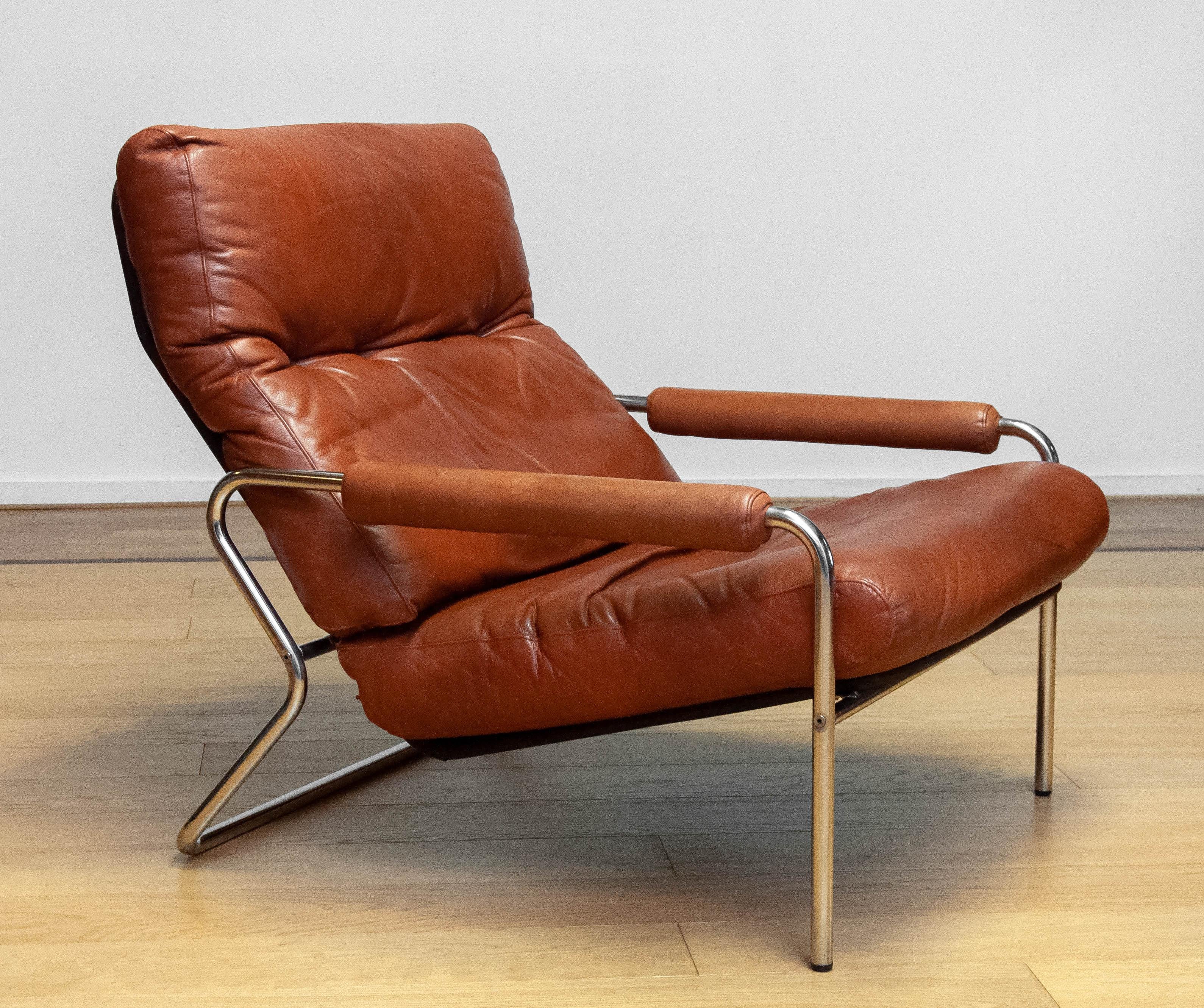 Beautiful tubular lounge chair with brown leather cushions and brown leather armrests from the 1960s made in Sweden.
The leather is in good condition even as the fillings and therefor the chair sits very comfortable.
The metal frame as well as the