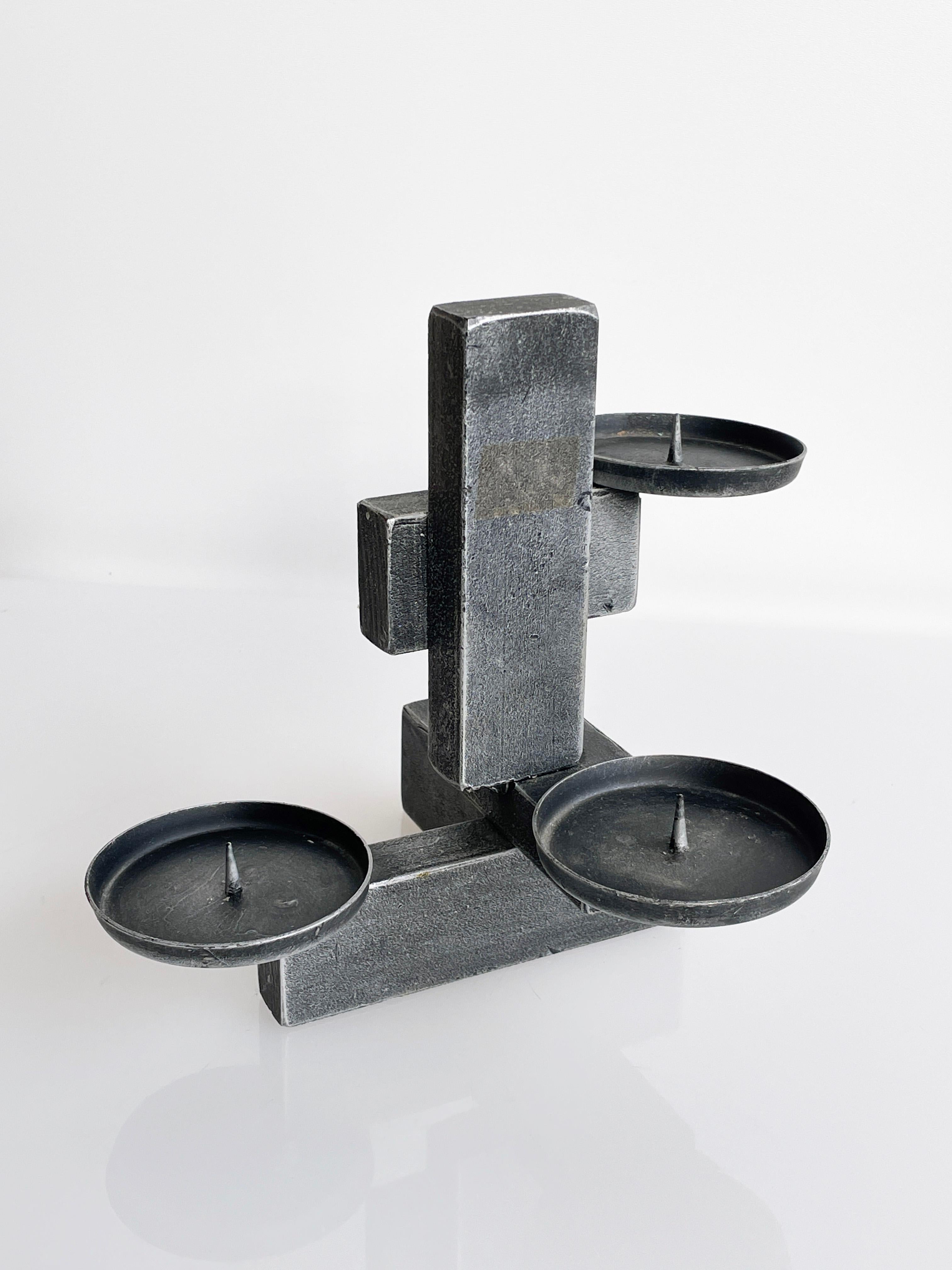 1960's Swiss Brutalist welded metal candle holder with three tiered candle cups. 
Three holders comfortably accommodate three thick light sources.
Height: 19.5cm / Width: 22cm / Depth: 19cm
