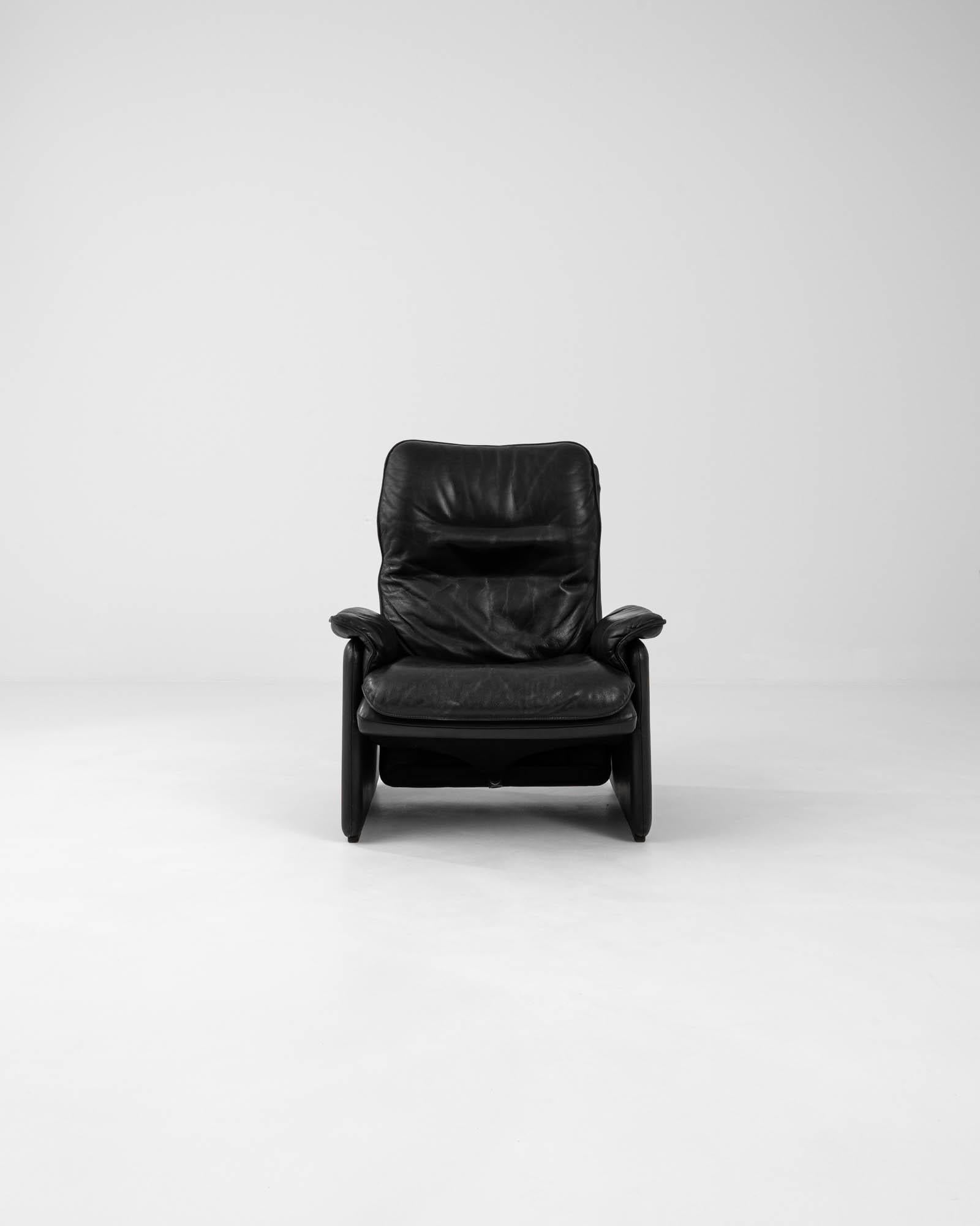 Introducing the quintessence of luxury and comfort with this 1960s Swiss leather armchair by De Sede, a renowned name in craftsmanship and design. Clad in sumptuous black leather, this chair features plush padding that envelops you in unparalleled