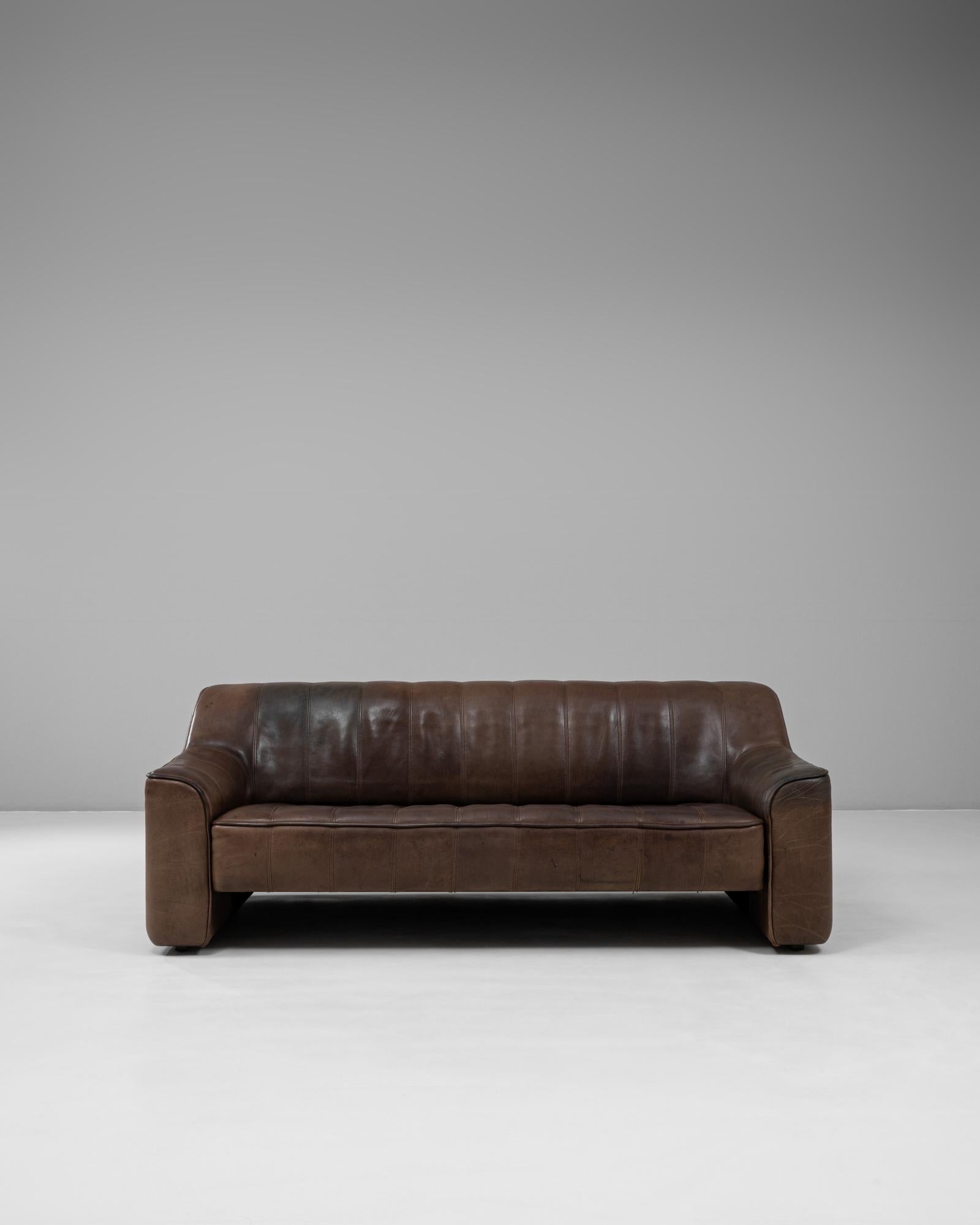 Sofá suizo de piel de los años 60, modelo DS-44 de De Sede. Este escultural diseño de tres plazas ejemplifica la reconocida artesanía de De Sede y su compromiso con el confort de lujo. Tapizado en flexible piel anilina marrón, el sofá muestra