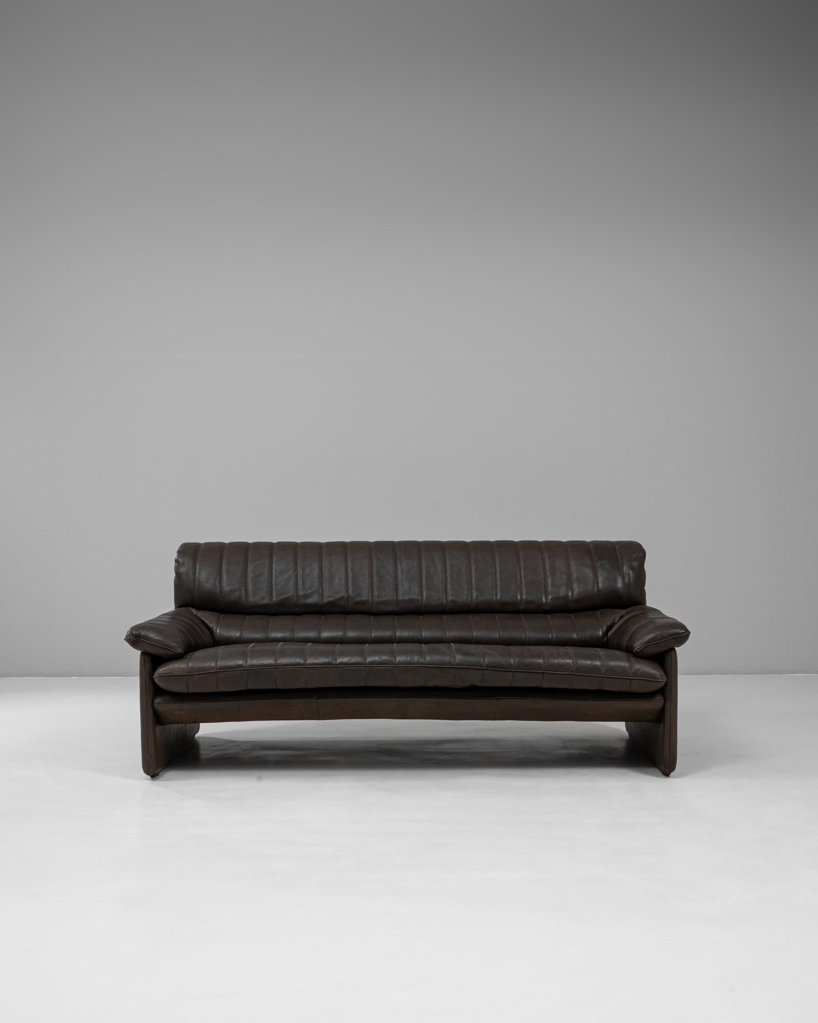 This piece is a 1960s Swiss Leather Sofa DS-86 by De Sede, a celebrated example of mid-century Swiss design. Upholstered in supple dark brown leather, the sofa reflects De Sede’s reputation for hand-crafted precision and luxurious comfort. The DS-86