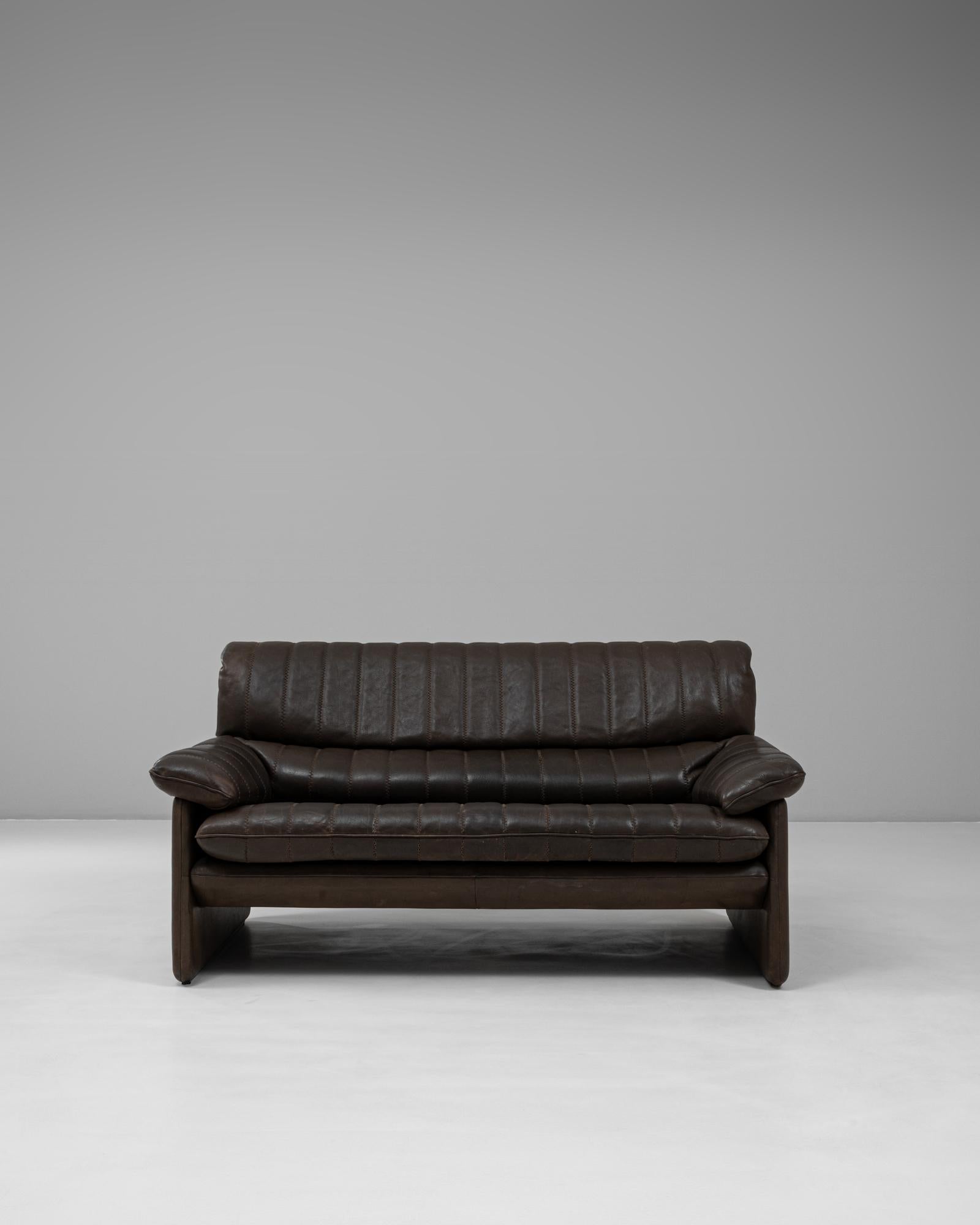 Ce canapé DS-86 en cuir suisse des années 1960 de De Sede illustre l'engagement de la marque en faveur d'un savoir-faire exceptionnel et d'un confort durable. Rembourrée en cuir patiné marron foncé, cette pièce présente les coutures cannelées