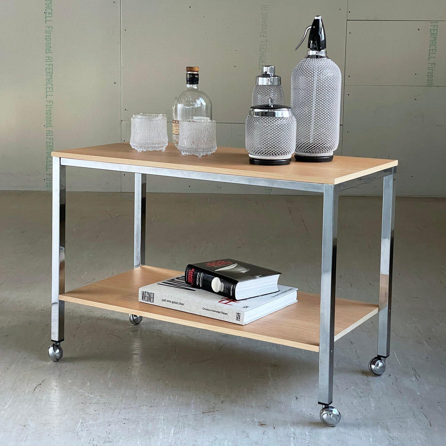 1960's Swiss minimalist drinks bar cart on coasters. Newly refinished with oak veneer. Also ideal for use as Stereo / Turntable / TV stand
Lovely example of Mid Century Swiss Minimalist home drinks bar cart. Chromed steel base with oak veneer