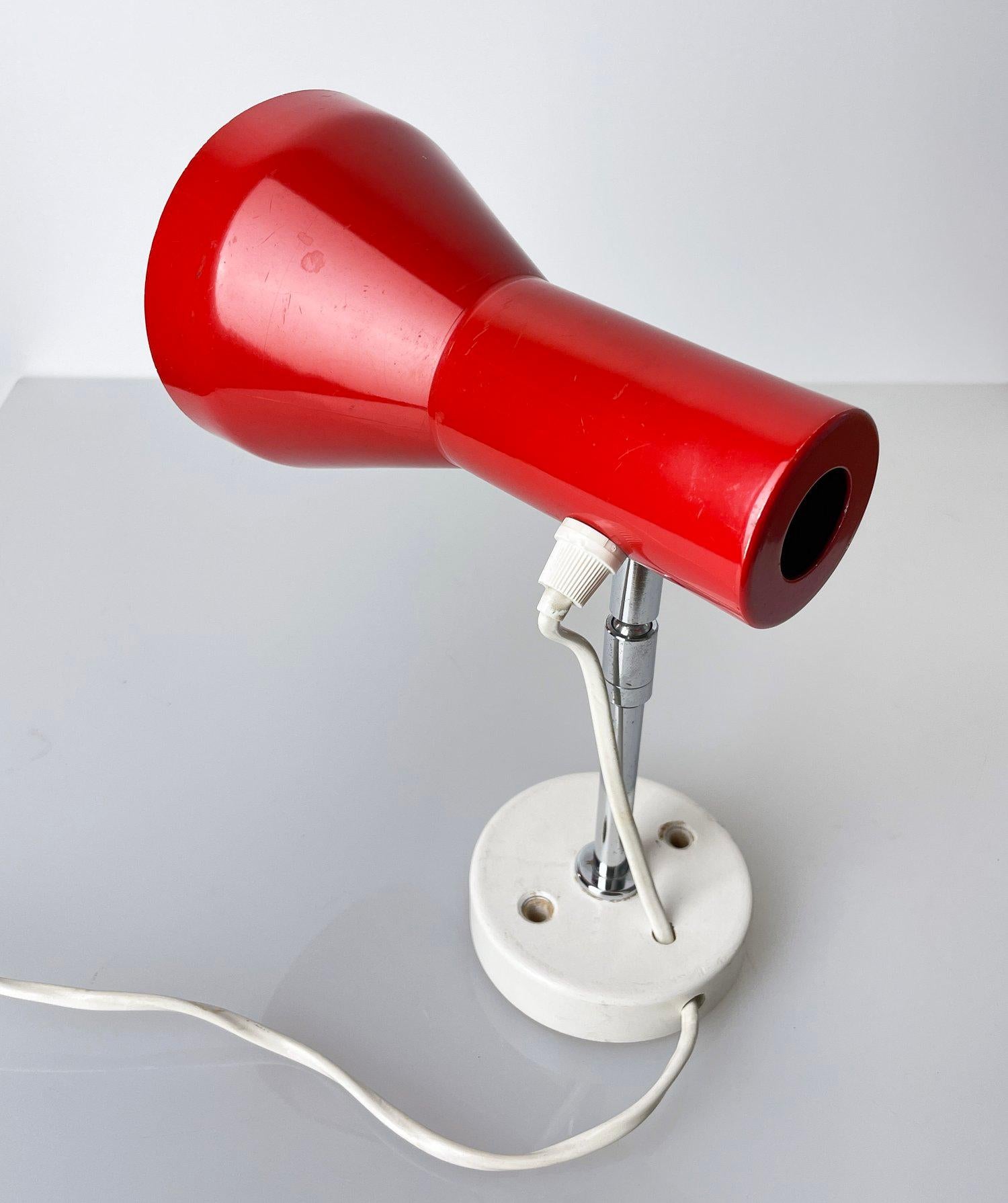 Lampe murale/plafonnier minimaliste des années 1960. Diffuseur de lumière en métal rouge avec bras en métal chromé sur un support mural en bois. Réglable pour un éclairage directionnel. Idéal pour l'éclairage de couloir ou de chevet. 

Produit
