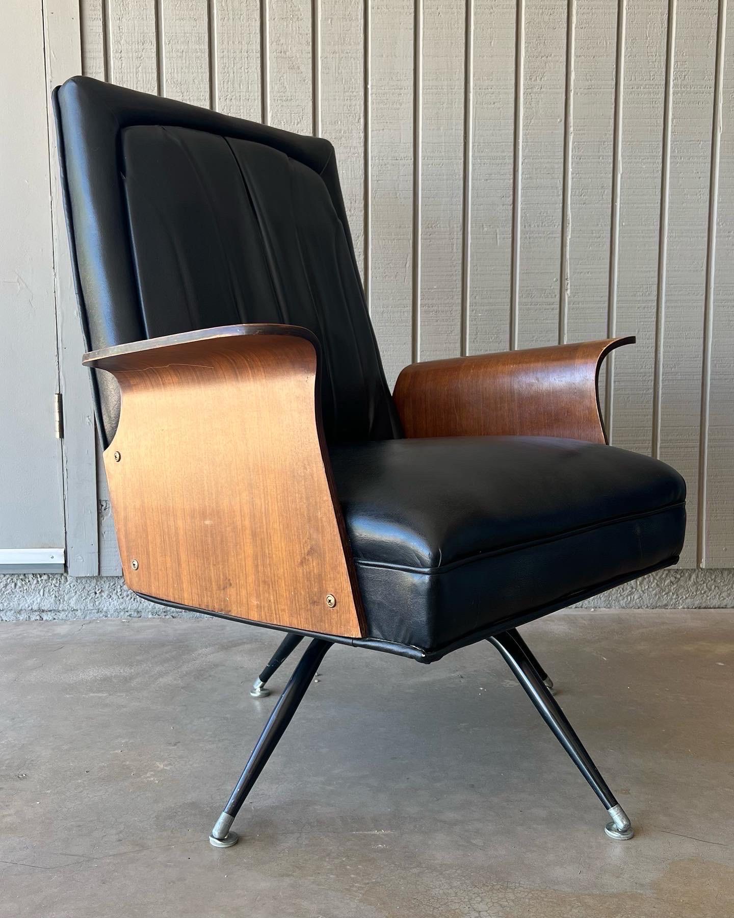 1960er Lounge-Sessel von Murphy-Miller, Inc. Dieser Sessel verfügt über skulpturale Armlehnen aus gebogenem Walnussholz, eine originale schwarze Vinylpolsterung und gespreizte Metallbeine. Er ist schwenkbar und wippt durch einen Federmechanismus. In
