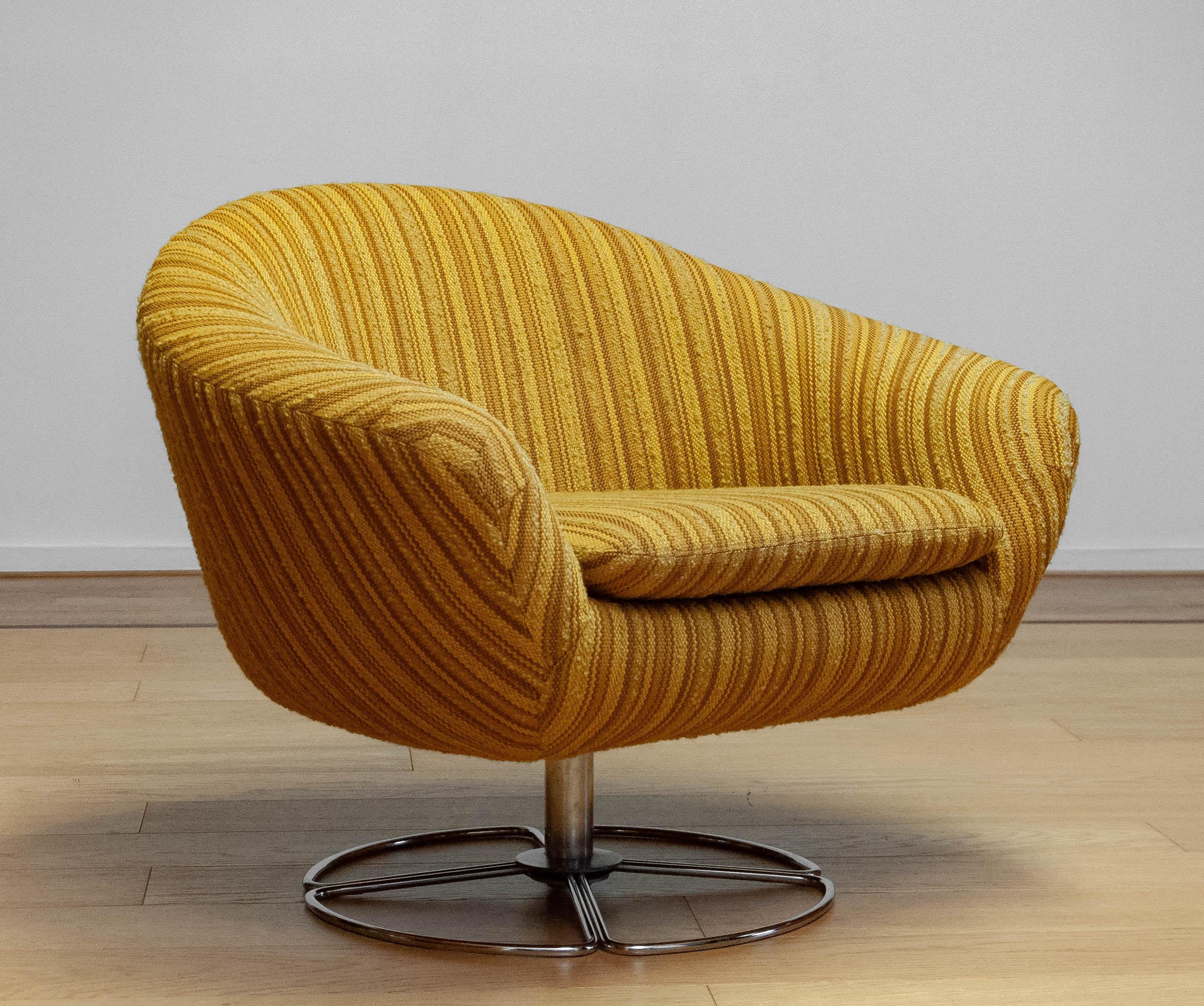 This 1960s Maize Yellow Bouclé Fabric Upholstered Swivel Chair by DUX of Sweden is a striking example of mid-century modern design. The chair features a sleek, sculptural silhouette with soft, organic curves that offer both comfort and style.
