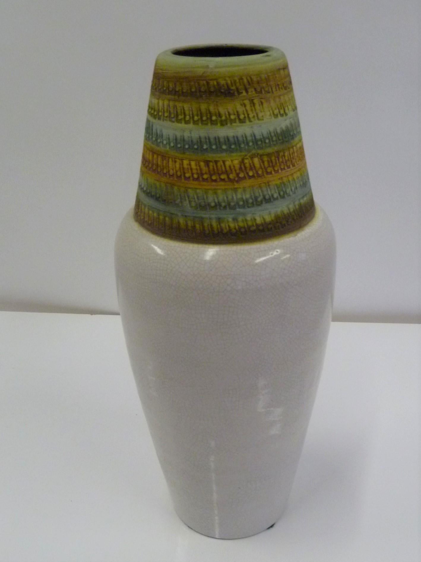 A 1960s import from Italy, this tall Bitossi Vase was designed by Alvino Bagni and has a shouldered form with a fine craquelure creamy glaze on the bottom topped with a textural impressed conical head and mouth in matte glaze in green and mustard
