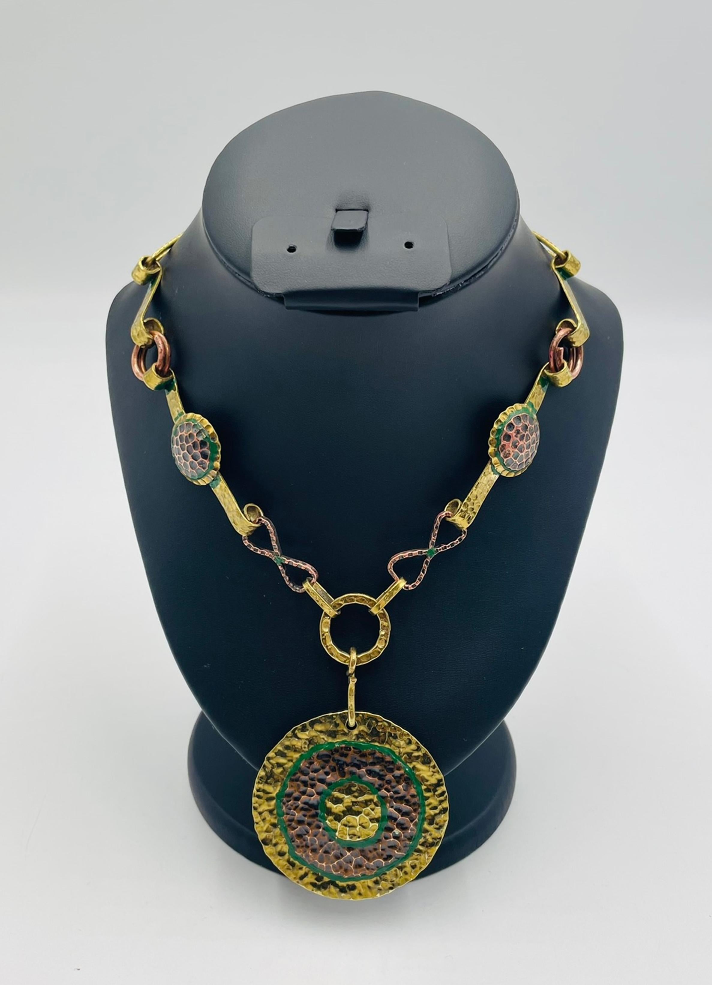 A striking mixed-metal modernist necklace designed and handcrafted in Mexico in the 1960s by the renowned jewelry studio Taller Maya. This bold and sculptural piece showcases the studio’s signature use of hammered brass, copper, and patinated