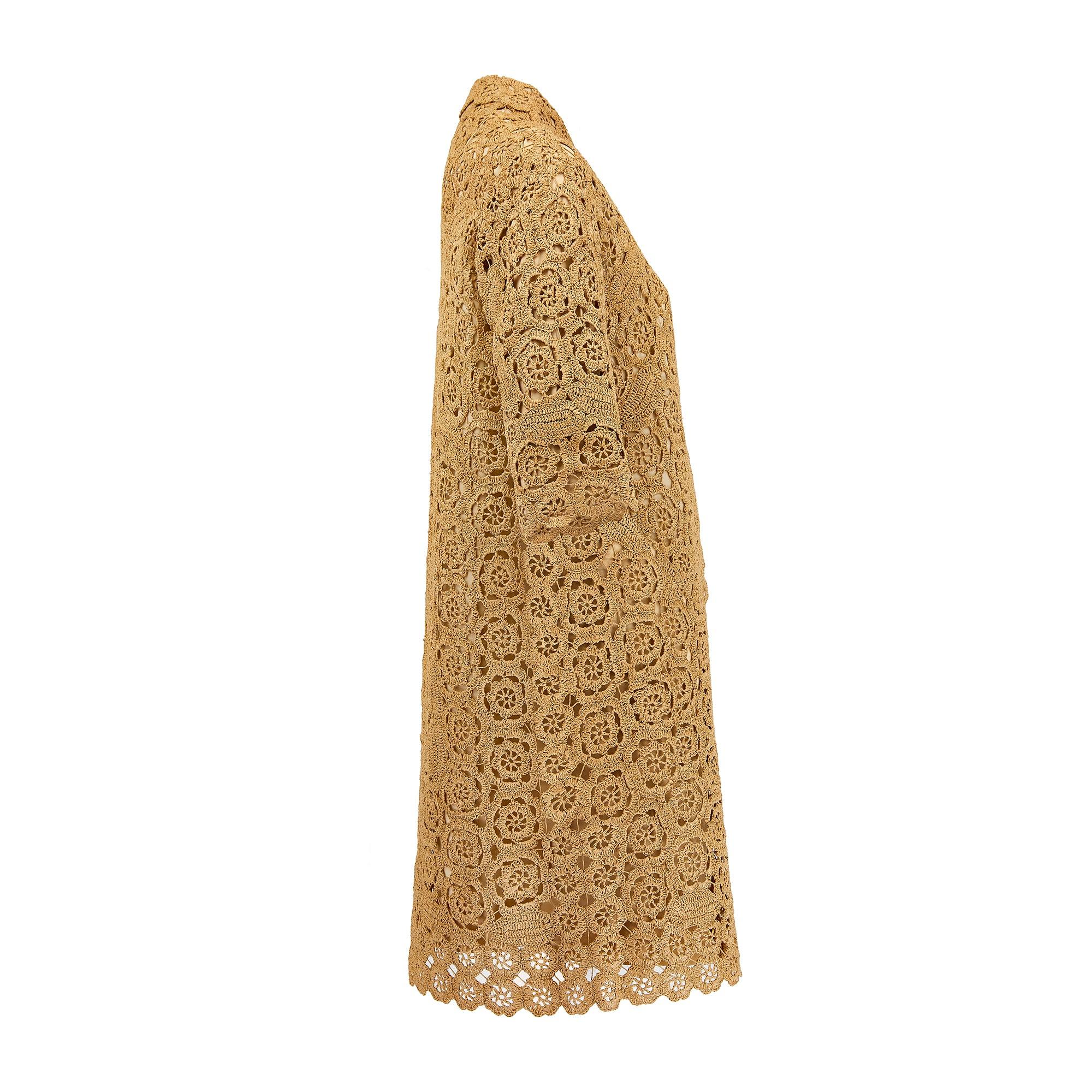 This 1960s handcrafted mid-length coat was most likely made in Italy from stiff tan raffia woven with floral motifs; it forms a cocooning silhouette around the wearer. The slouchy drop-shoulders and a laid-back soft collar make it highly adaptable -