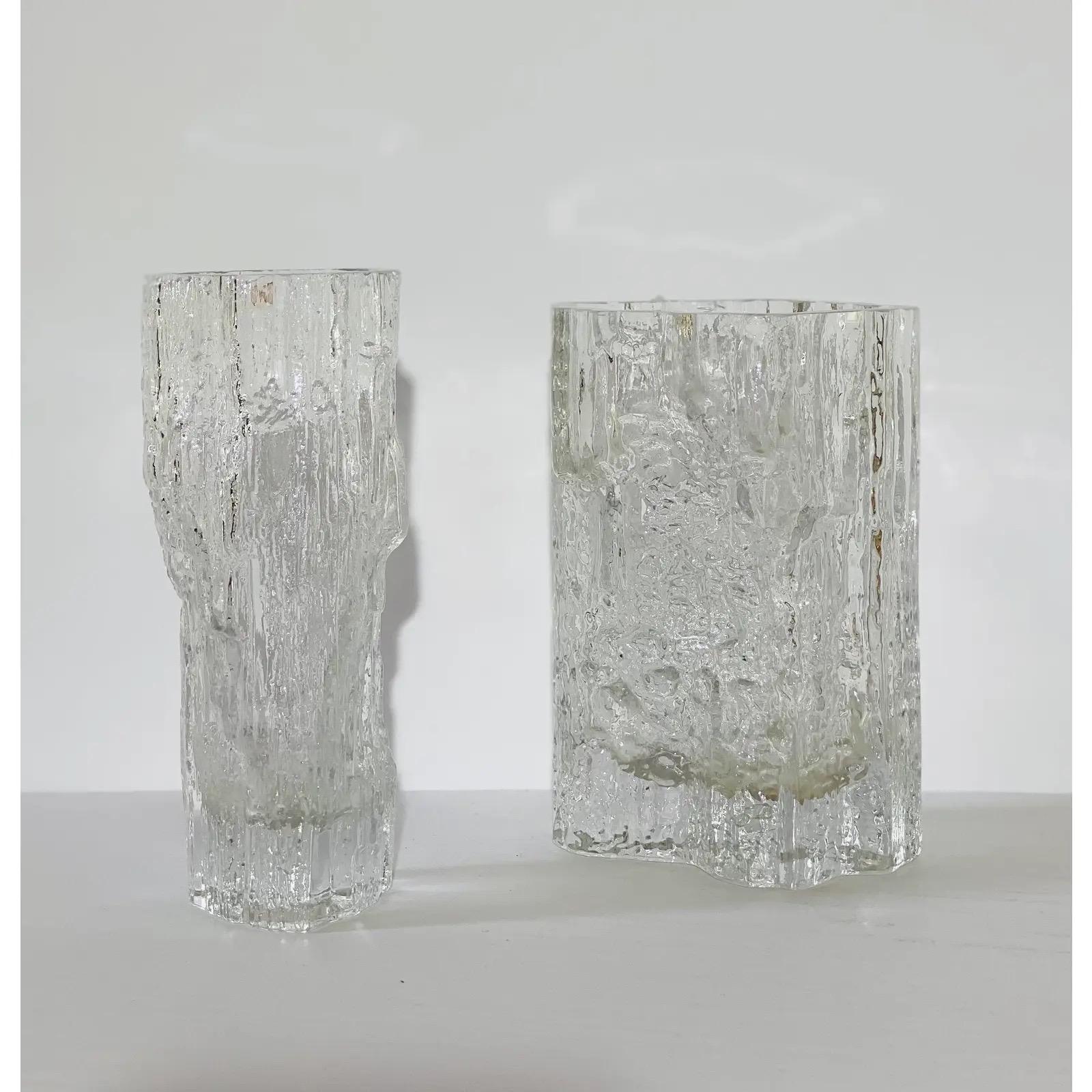 We are very pleased to offer two vases by designer and sculptor Tapio Wirkkala for littala, circa the 1960s. The glass pair showcases a block textured ice pattern. The larger vase has a small chip on the rim; however due to its natural texture is