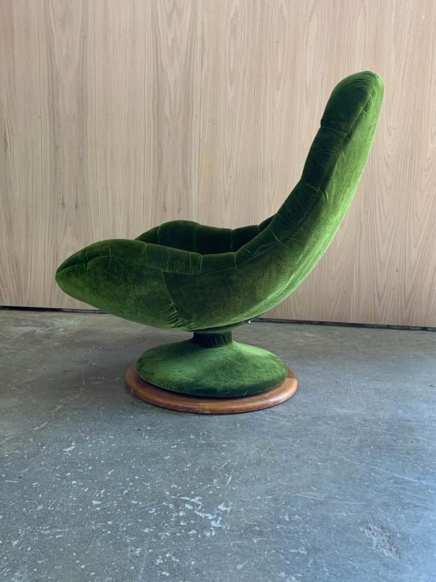 A striking 1960s swivel scoop chair designed by R. Huber, freshly reupholstered in rich, emerald green velvet that adds a vibrant, luxurious feel. Set on a sculptural solid teak base, the chair’s flowing, organic form and deep tufted seat offer both