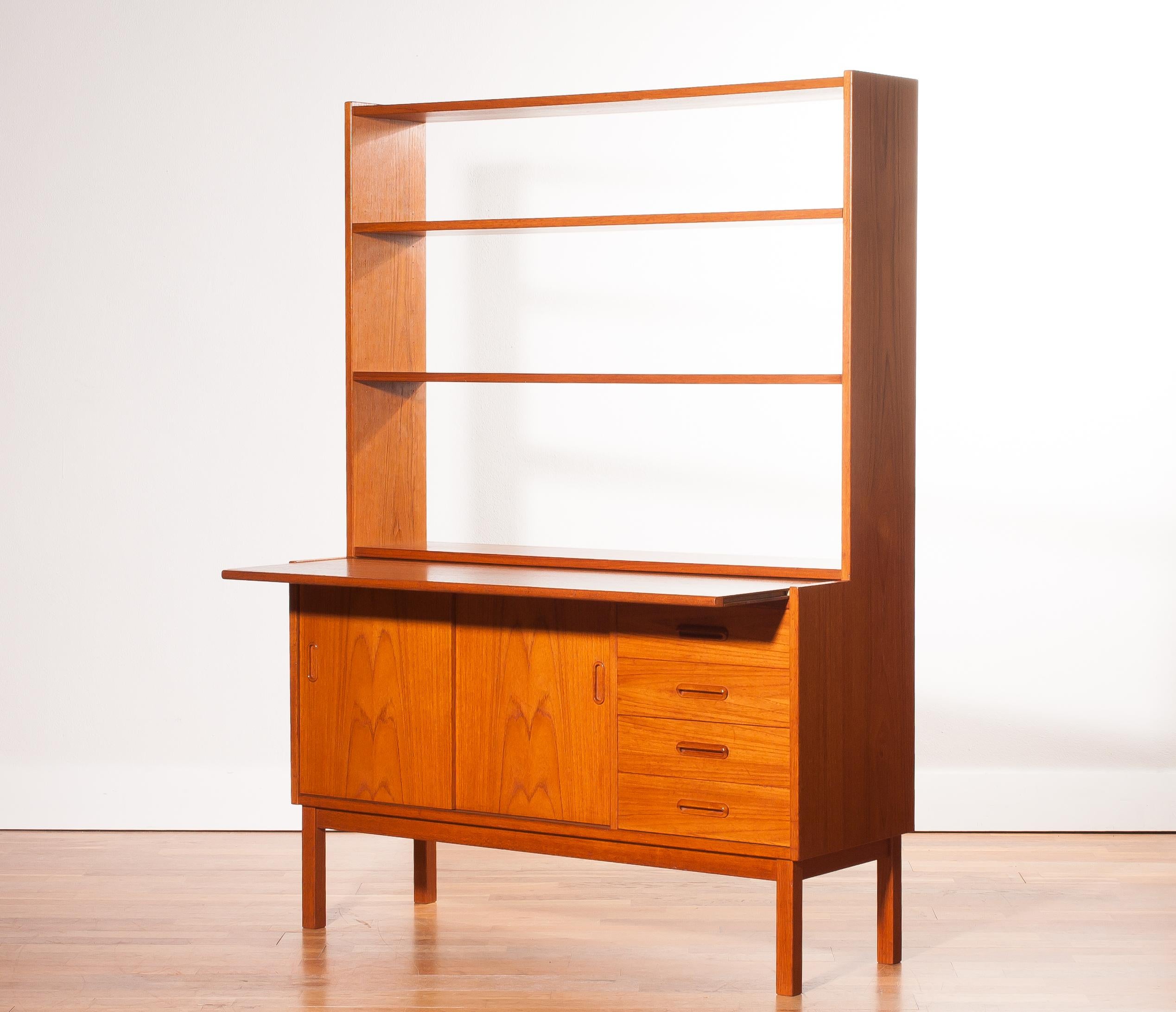 Very beautiful bookcase with slidable writing space produced in Sweden.
This cabinet is made of teak.
The cabinet has two sliding doors and four drawers.
With the writing sheet extended is the cabinet 62 cm deep and is the writing tablet 39 cm
