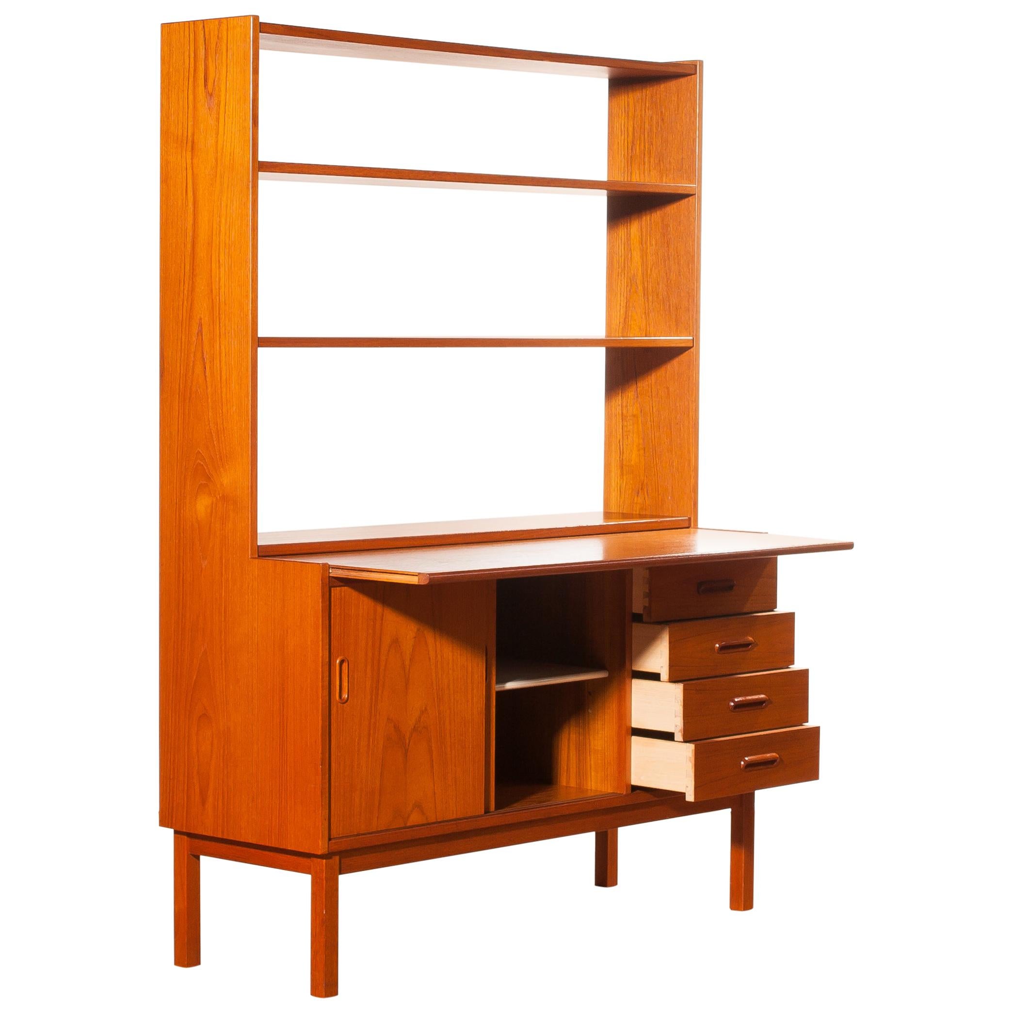 Very beautiful bookcase with slid able writing space produced in Sweden.
This cabinet is made of teak.
The cabinet has two sliding doors and four drawers.
With the writing sheet extended is the cabinet 62 cm deep and is the writing tablet 39 cm