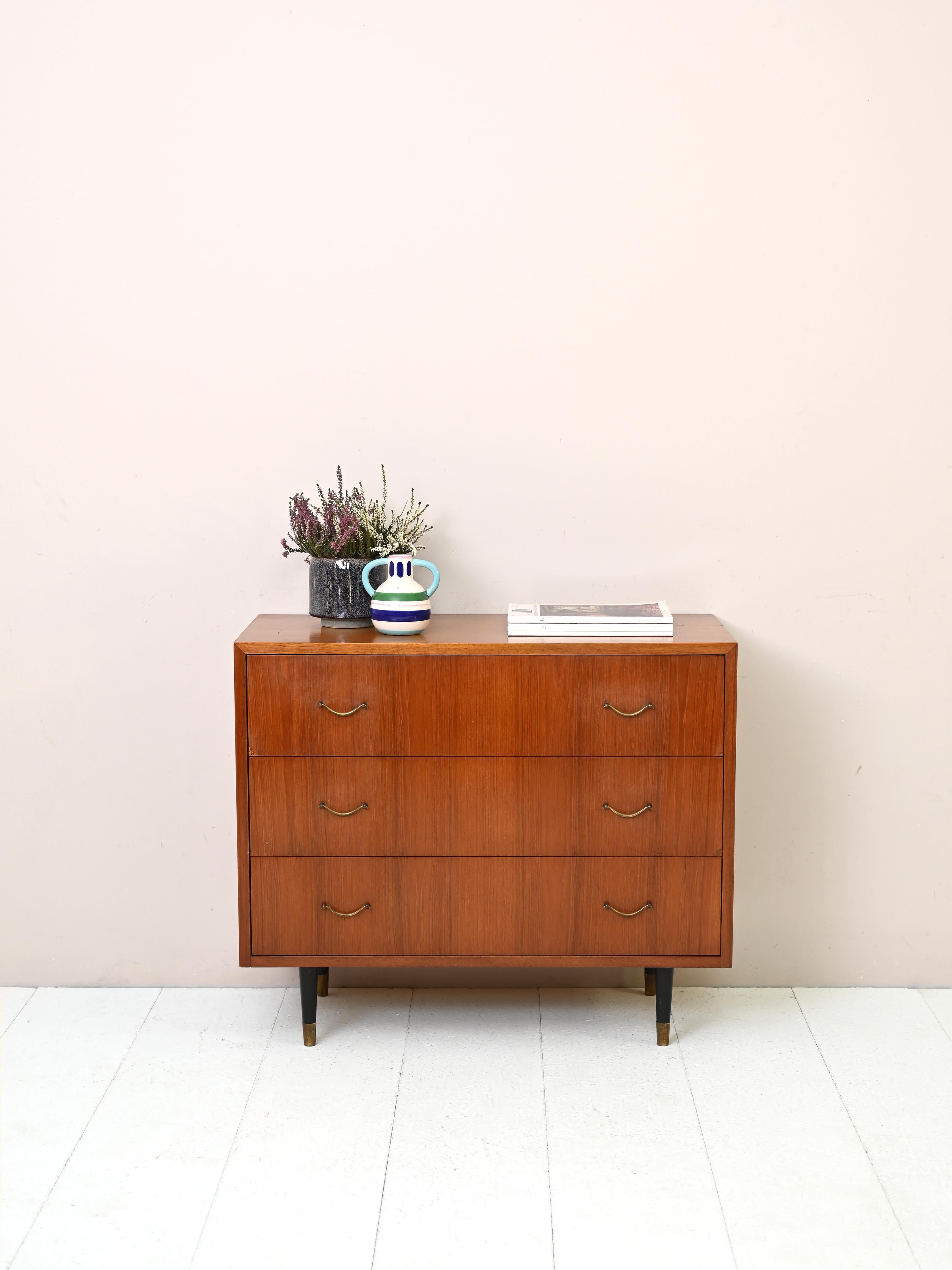 Vintage Scandinavian cabinet with drawers.

This chest of drawers is characterized by the square and regular shape of the frame embellished with golden details and black painted wooden legs.
Despite its small size, the drawers are spacious and