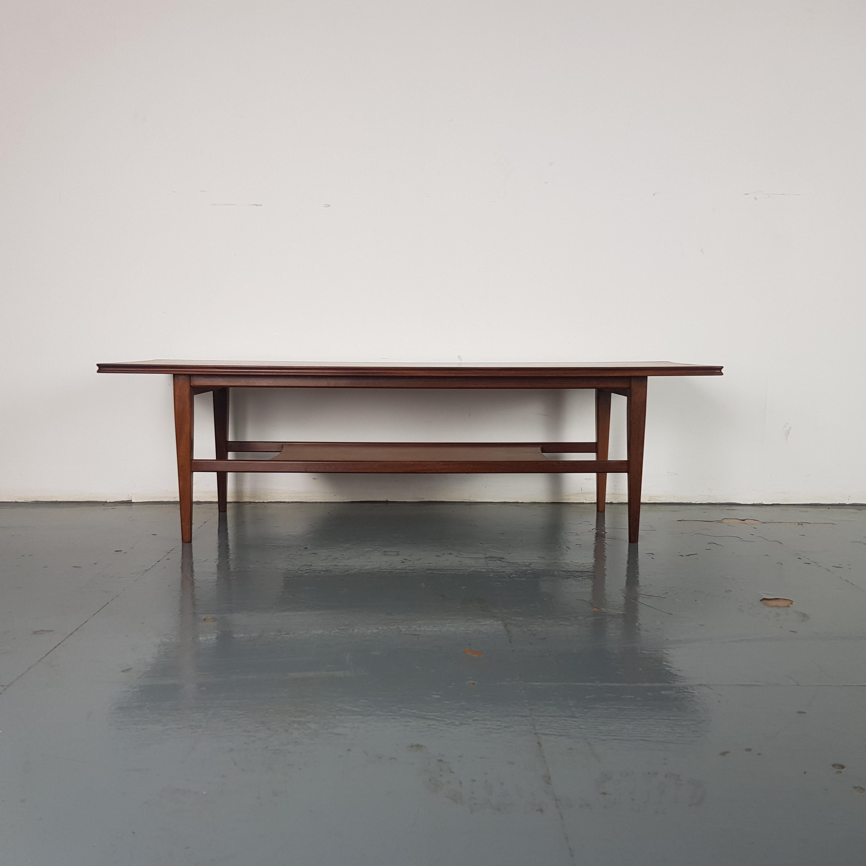 Classic midcentury two-tier coffee table by Richard Hornby for Heal's.
In good vintage condition, with some wear commensurate with age and use, but nothing specific to mention.

Approximate dimensions:

Width 105cm

Depth 43cm

Height