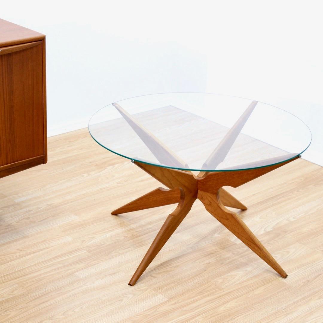 Cette table basse ronde du milieu du siècle a été conçue par Vladimir Kagan pour Sika Môblër. dans les années 1960. Fabriquée en teck massif et dotée d'un plateau en verre, cette table d'appoint minimaliste se distingue par la beauté de son support.