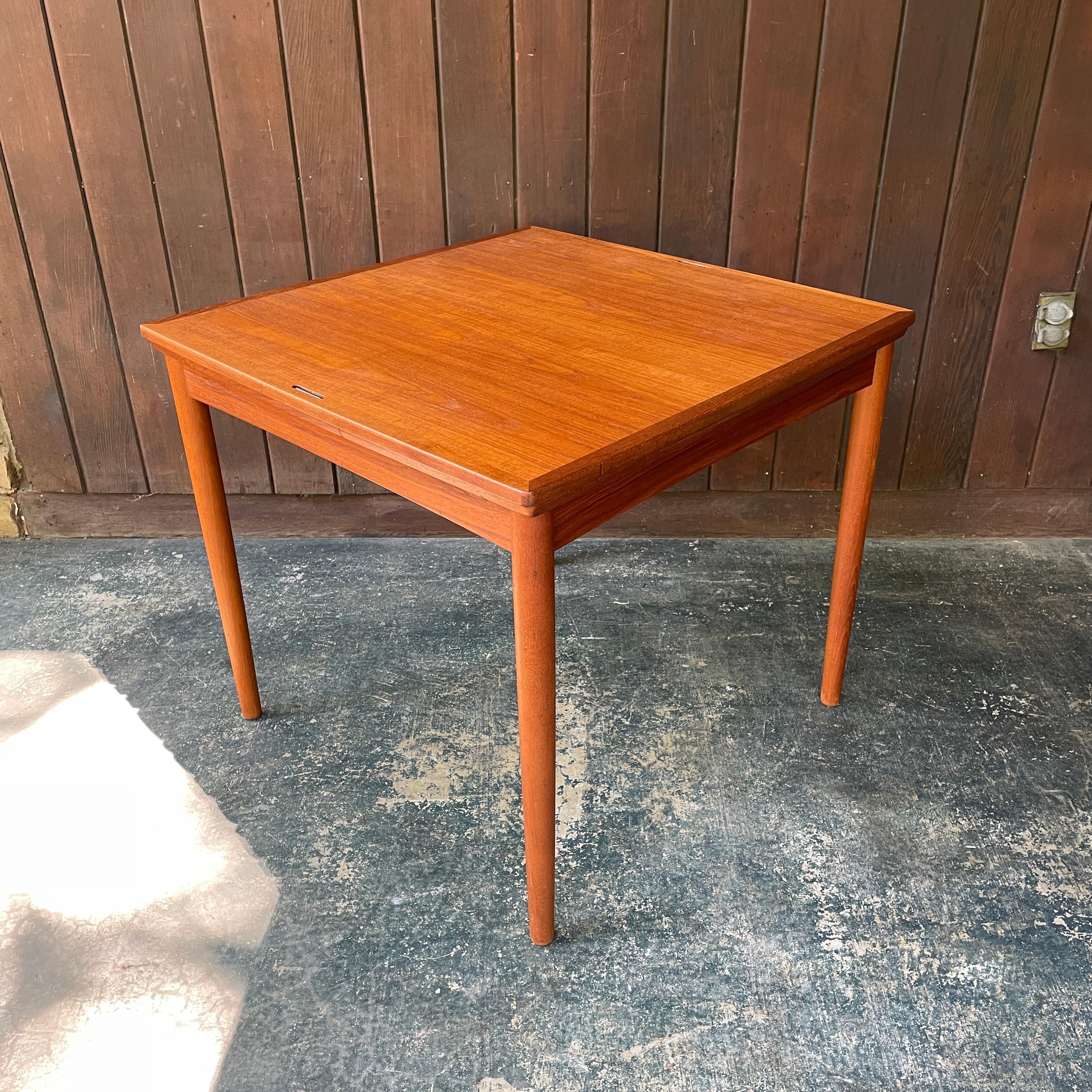 Une table compacte de fabrication danoise, de la taille d'un appartement, de 31,5 pouces carrés, avec deux allonges de 12,5 pouces qui peuvent s'étendre indépendamment ou ensemble pour prendre en sandwich le panneau central jusqu'à une longueur de