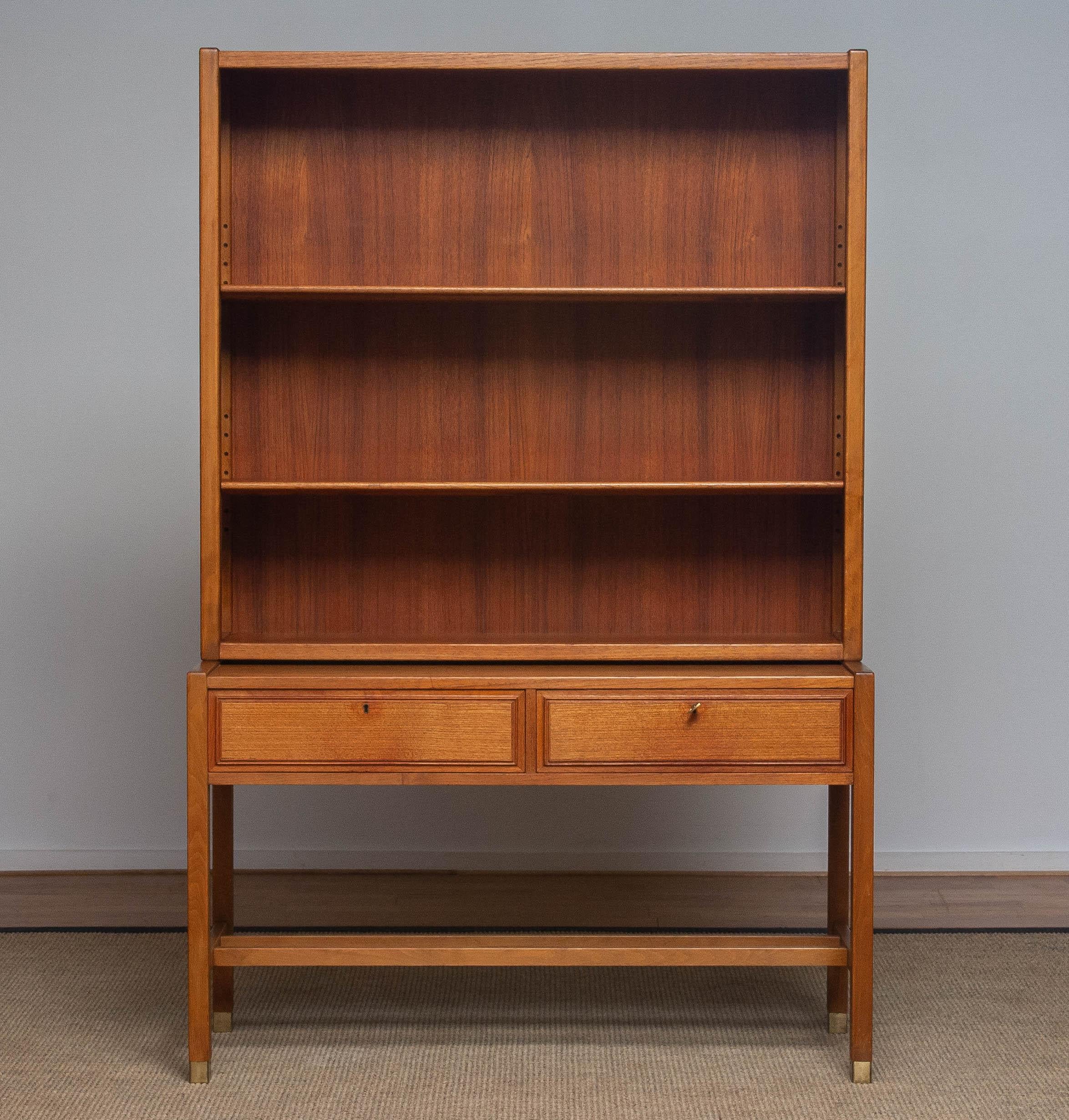 Elegant teak bookcase cabinet build up with a two lockable drawers sideboard underneath and a cabinet on top in which are two adjustable shelf.
Build up in high quality materials and overall in good condition.
Designed by Carl-Axel Acking for