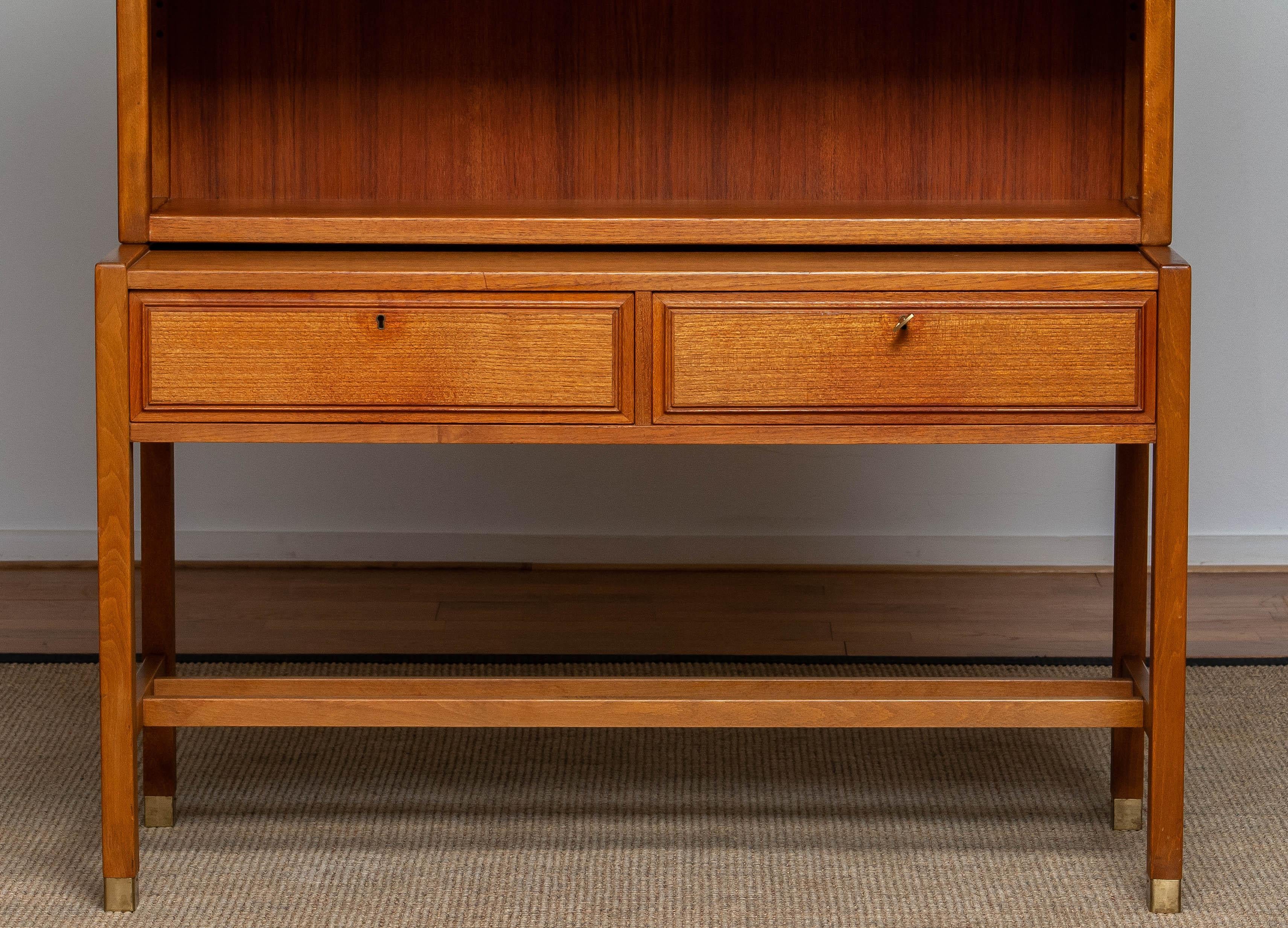 Elegant teak bookcase cabinet build up with a two lockable drawers sideboard underneath and a cabinet on top in which are two adjustable shelf.
Build up in high quality materials and overall in good condition.
Designed by Carl-Axel Acking for