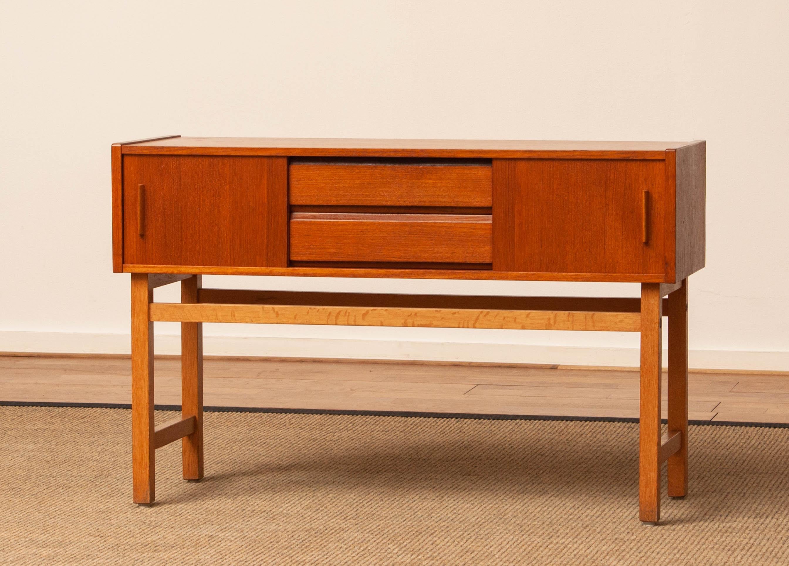 Beautiful small console / Hall cabinet / entry credenzas in teak resting on a beech stand and made in the 1960's in Sweden.
This small cabinet consists two drawers as wel as two sliding doors.
Overall in good condition.

Please note!
Because