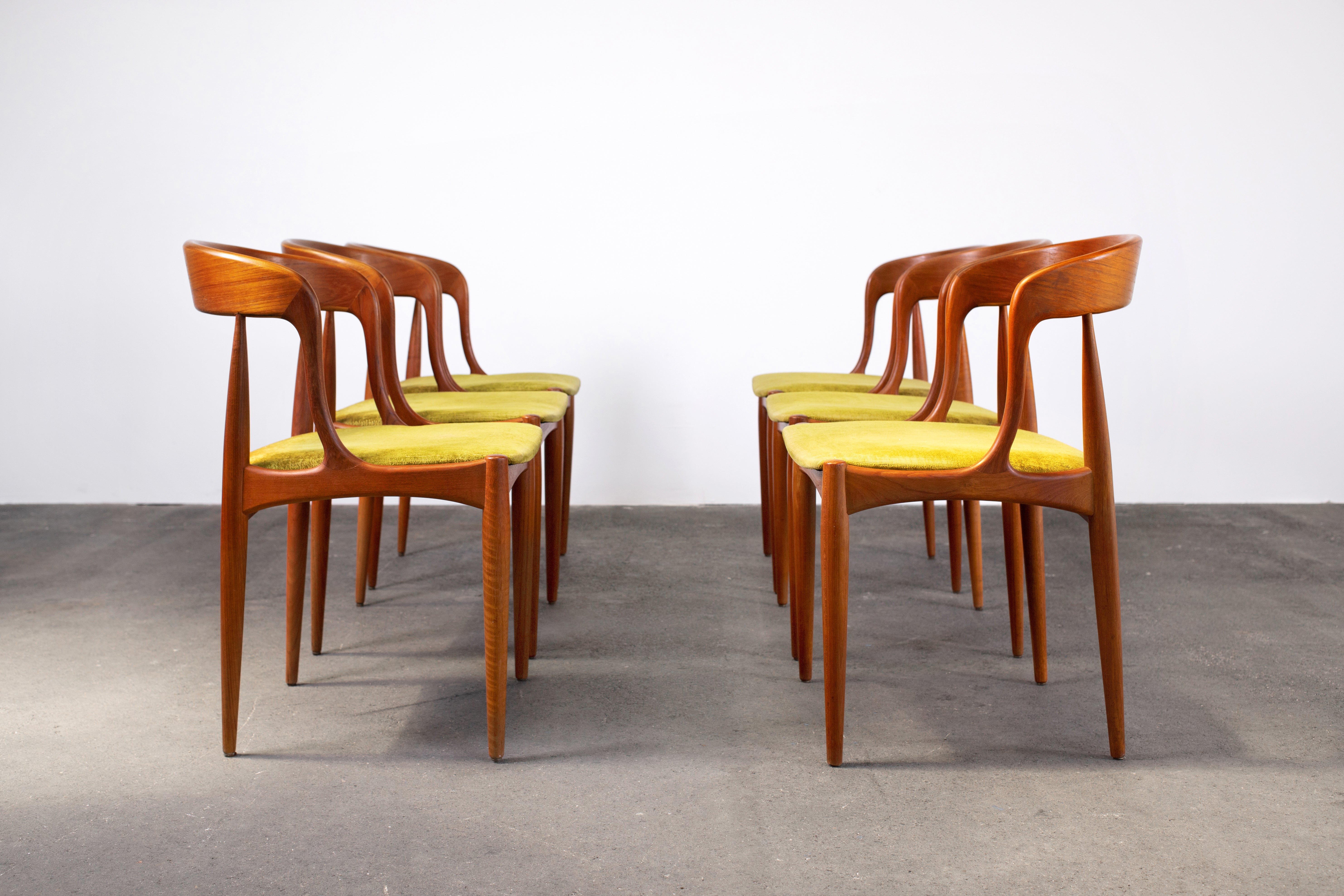 Set of 6 Scandinavian Modern curved dining chairs by Johannes Andersen for Uldum Møbelfabrik Denmark. Carved from solid teak wood, these cult classic chairs are an icon of Danish Mid-Century Modern Design and craftsmanship. The organic form is