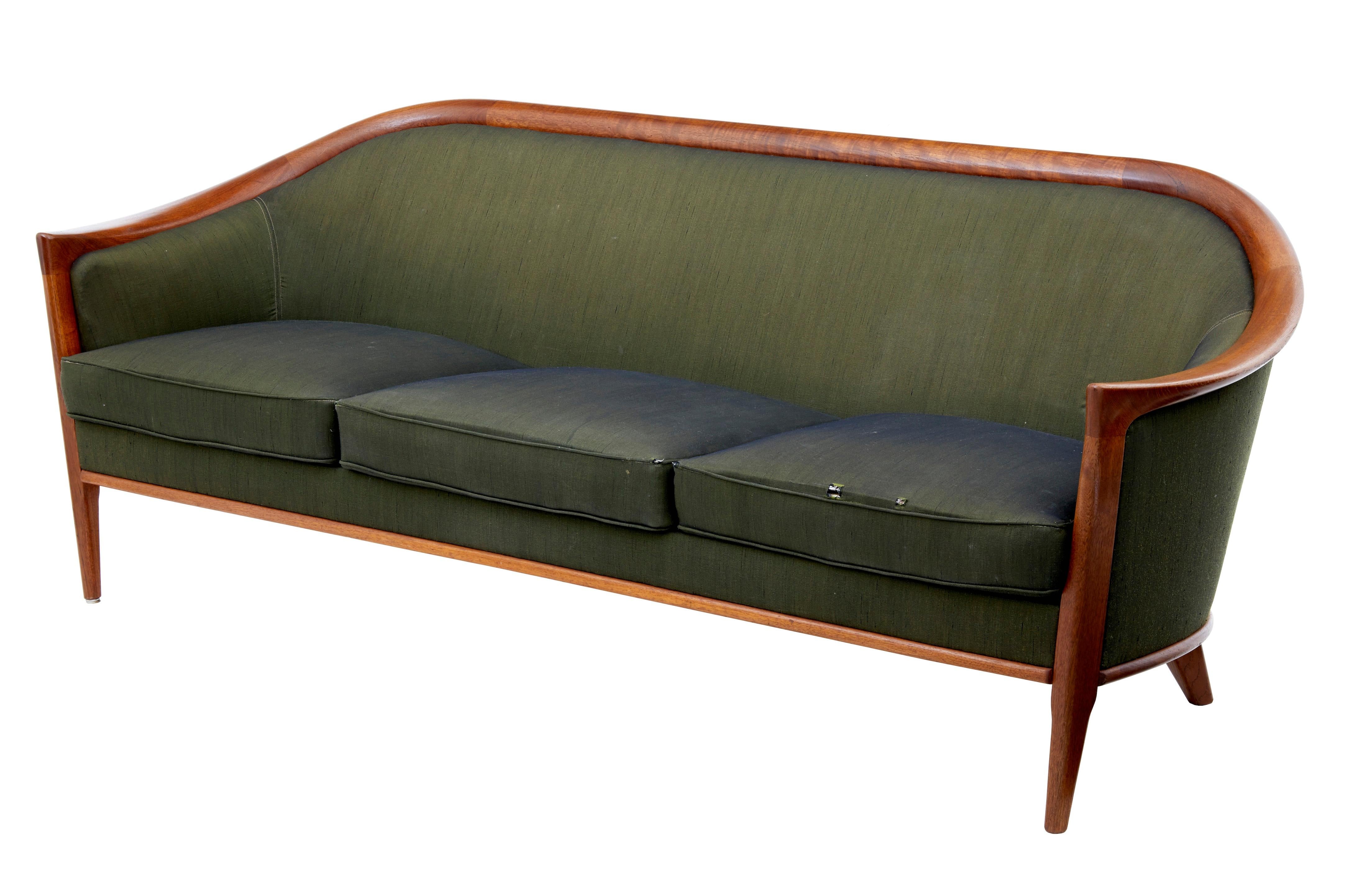 Fine piece of Scandinavian design, classic horseshoe shaped back in teak. Upholstered in olive green material. Some light staining and holes to the front edge of two sofa cushions exposing the metal work framing. Ideal for recovering the